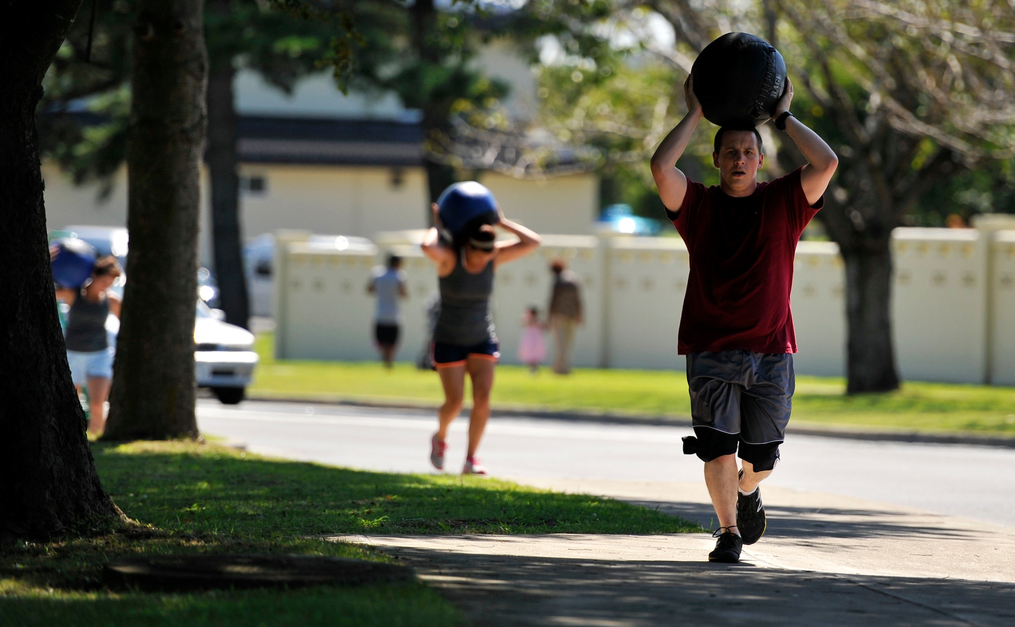 Warrior Fit class participants carry medicine balls while completing a 400-meter run at Misawa Air Base, Japan, Sept. 7, 2012. Warrior Fit involves a series of different exercises, which include weightlifting, gymnastics, running and rowing for a full-body workout experience. (U.S. Air Force photo by Airman 1st Class Zachary Kee/Released)