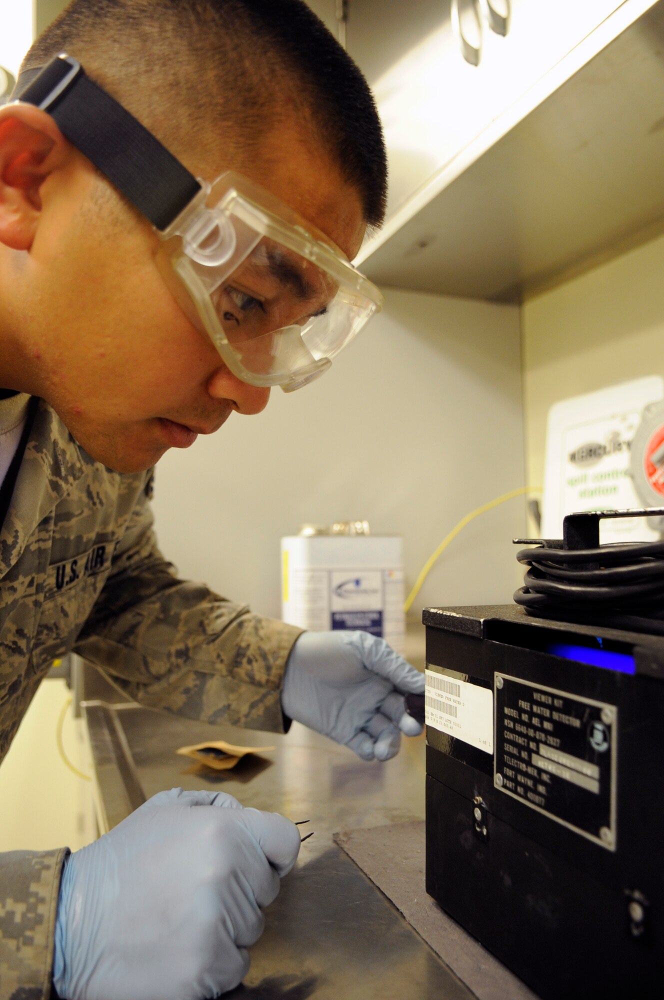Staff Sgt. Benny Cruz, 8th Logistics Readiness Squadron fuels lab NCO in charge, checks a fuel sample for water at Kunsan Air Base, Republic of Korea, Sept. 4, 2012. If any water is on the pad, it will show up as a bright green beneath the light. (U.S. Air Force photo/Senior Airman Brigitte N. Brantley)