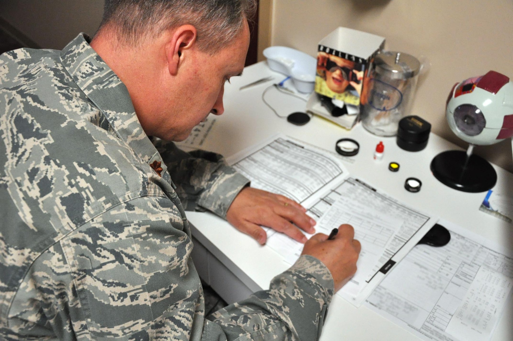 AURORA, Colo. – Maj. Dan Gullekson, 460th Medical Operations Squadron Optometry Element chief, writes a prescription for an Airman’s new glasses Sept. 5, 2012, at the Buckley Air Force Base Optometry Clinic. Approximately 15 patients are seen each day by the optometry clinic for services ranging from basic eye exams to managing pre- and post-operative care after refractive surgery. (U.S. Air Force photo by Staff Sgt. Kali L. Gradishar)