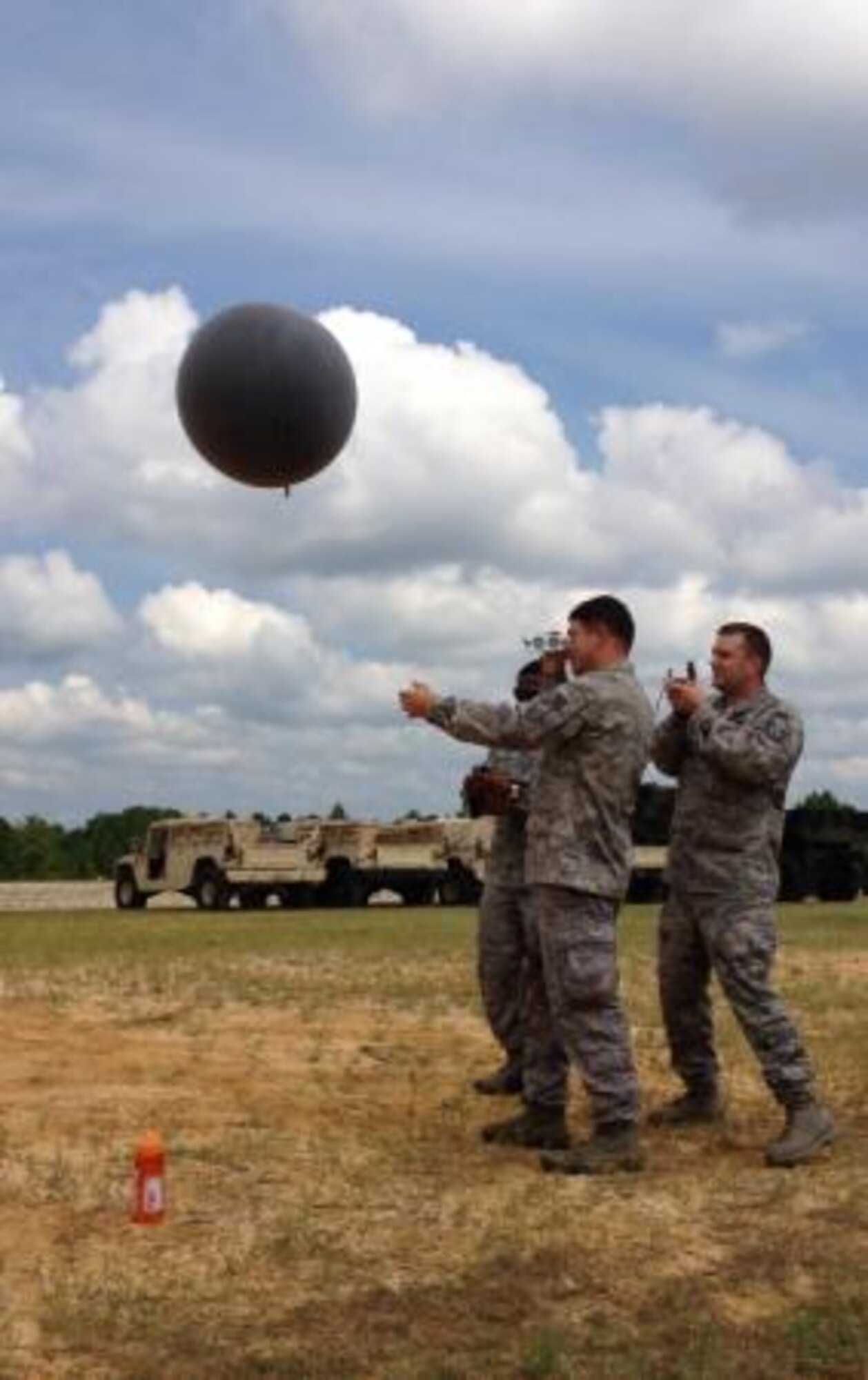 Air Force Staff Sgt. Christopher Quimby, a battlefield forecaster attached to Task Force Wings, launches a tactical weather balloon to measure winds at flight levels, while holding an instrument to measure elevation during a Joint Operations Aviation Exercise at Fort Bragg, N.C., Aug.23. His wingmen measure wind direction and record the findings. (U.S. Air Force photo by 1st Lt. Lauren McQuone, Detachment 4, 18th Weather Squadron)