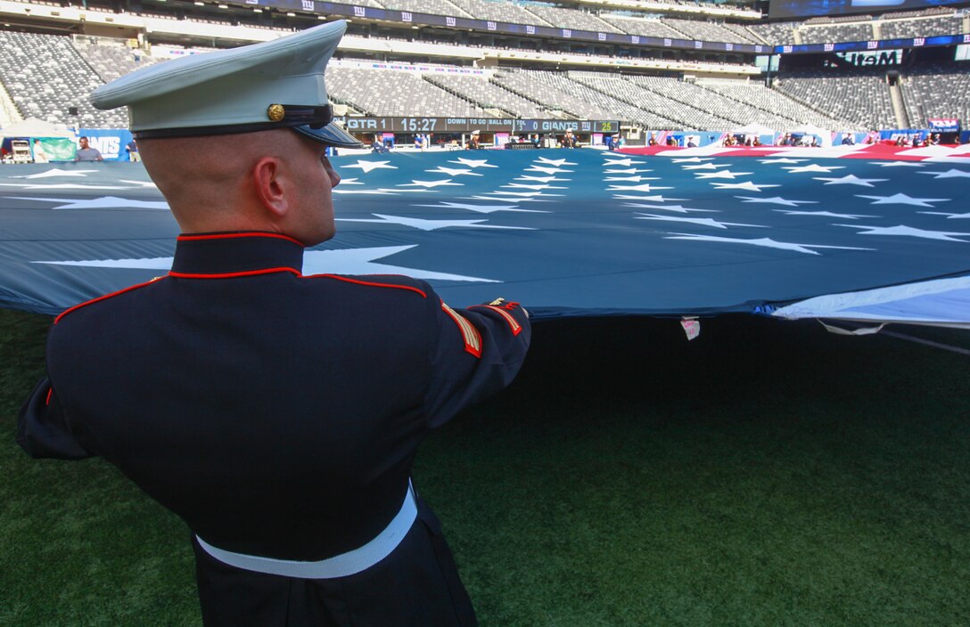 EAST RUTHERFORD, N.J. – Staff Sgt. Richard Ison, a recruiter with Recruiting Station New Jersey, along with other Marines, sailors, Coast Guardsmen, airmen and soldiers unfurled an American flag across the field during a  ceremony practice before the New York Giants vs. Dallas Cowboys game at MetLife Stadium, Sept. 5.  More than 60 service members presented the large flag as Queen Latifah sang the national anthem.  (U.S. Marine Corps photo by Cpl. Caleb T. Gomez).