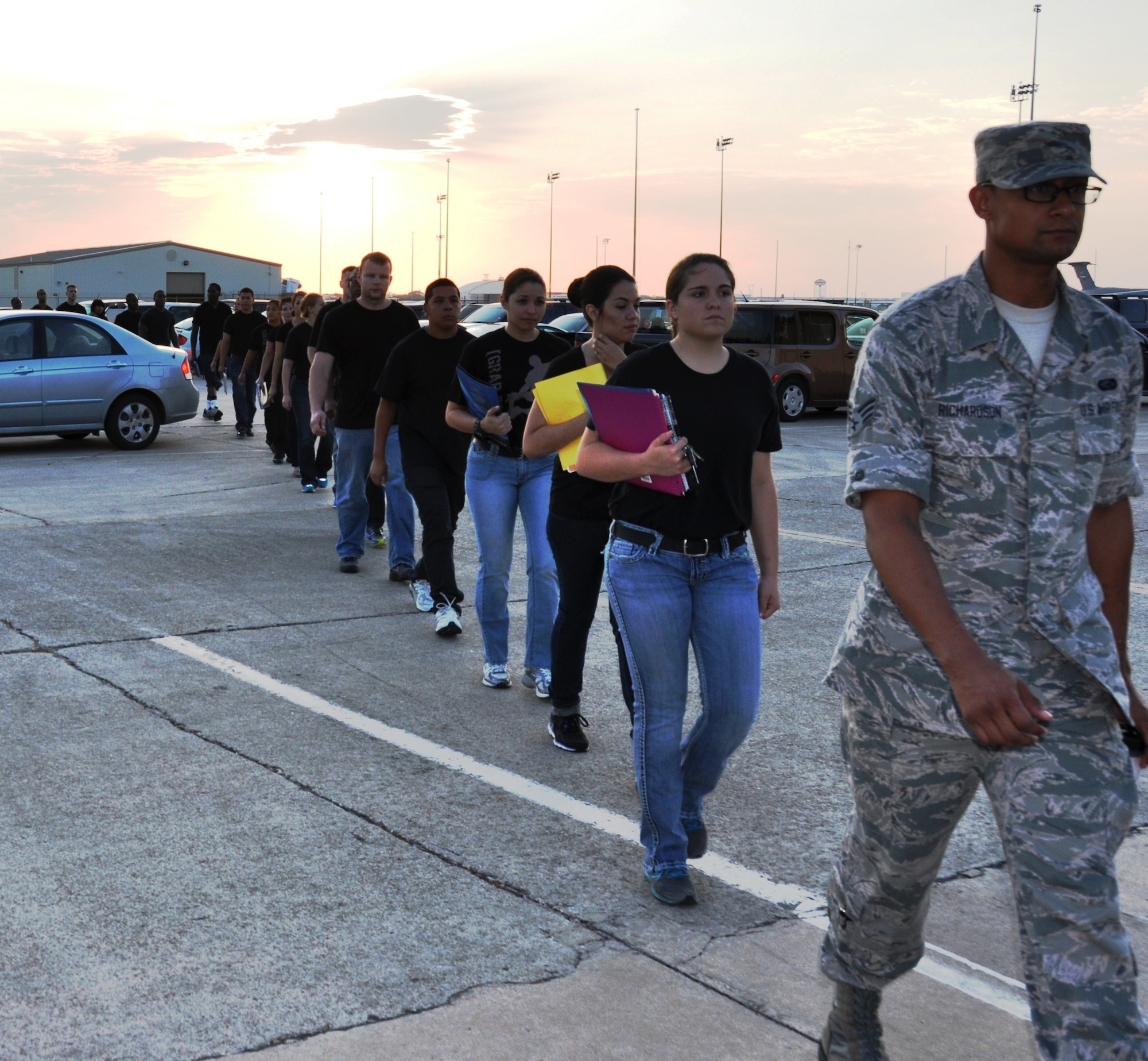 Senior Airman William Richardson,433rd Airlift Wing Career Development office, leads 26 trainees to their first meeting with 433rd Airlift Wing Commander Col. Jeffrey T. Pennington.  The mission of the Delayed Entry Training Flight is to prepare the trainees for Basic Military Training and help the new enlistees with the transition from civilian life to Airmen. (U.S. Air Force photo/Tech. Sgt. Carlos J. Trevino)