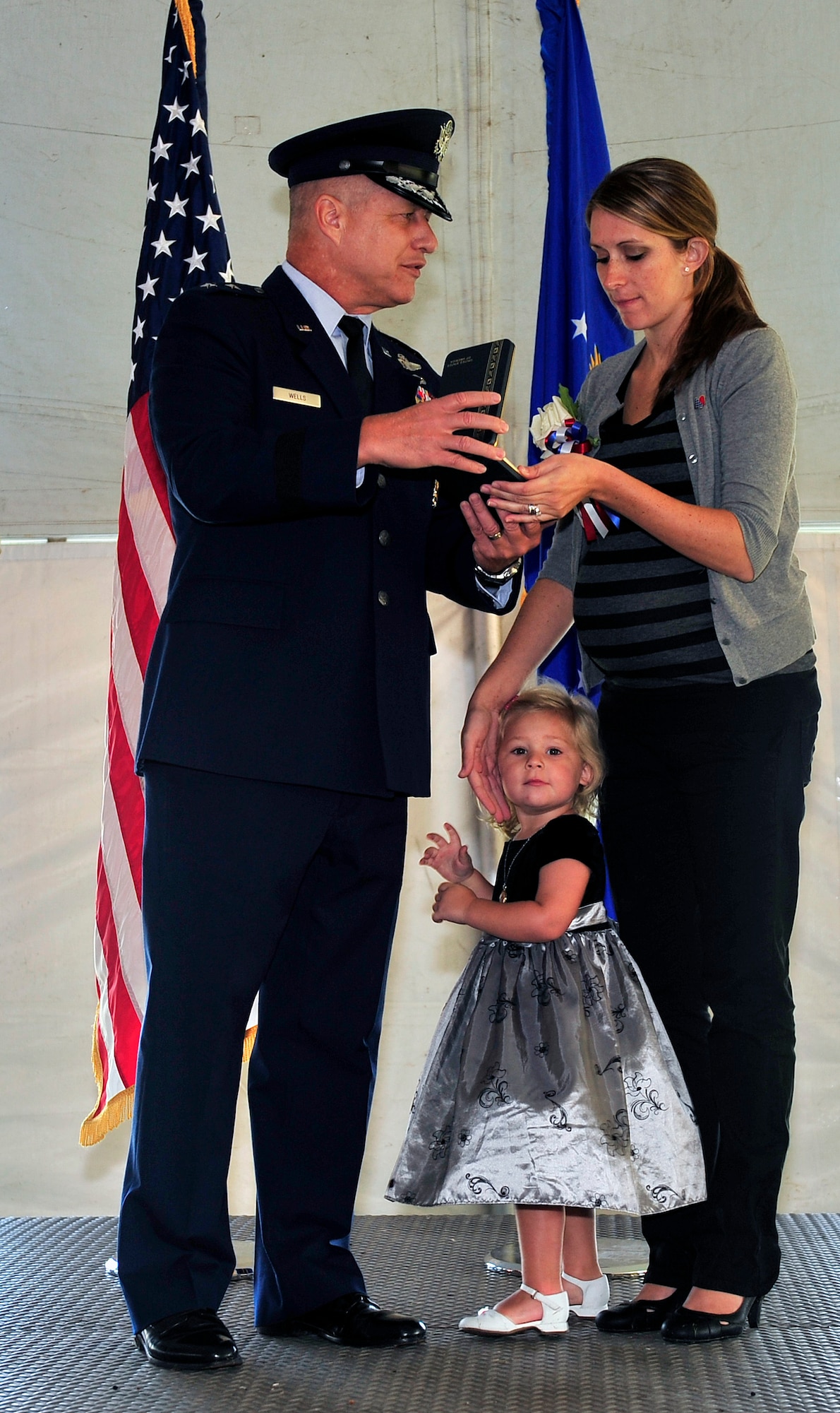 Maj. Gen. Lawrence L. Wells, 9th Air Force commander, presents the Silver Star to Tiffany Smith, widow of Senior Airman Bradley Smith during a ceremony Sept. 8, 2012 in Troy, Ill.  Smith spent only a few weeks with his new daughter, Chloe, now almost age 3, before deploying to Afghanistan where just months later he was killed by an IED during a firefight. As a Tactical Air Control Party member, or TACP, Brad was part of a two-man team assigned to support a 13-man Army platoon and was trained to call in close air support should the men come under fire and need the battlefield neutralized from above. (U.S. Air Force photo/ Staff Sgt. Stephenie Wade)