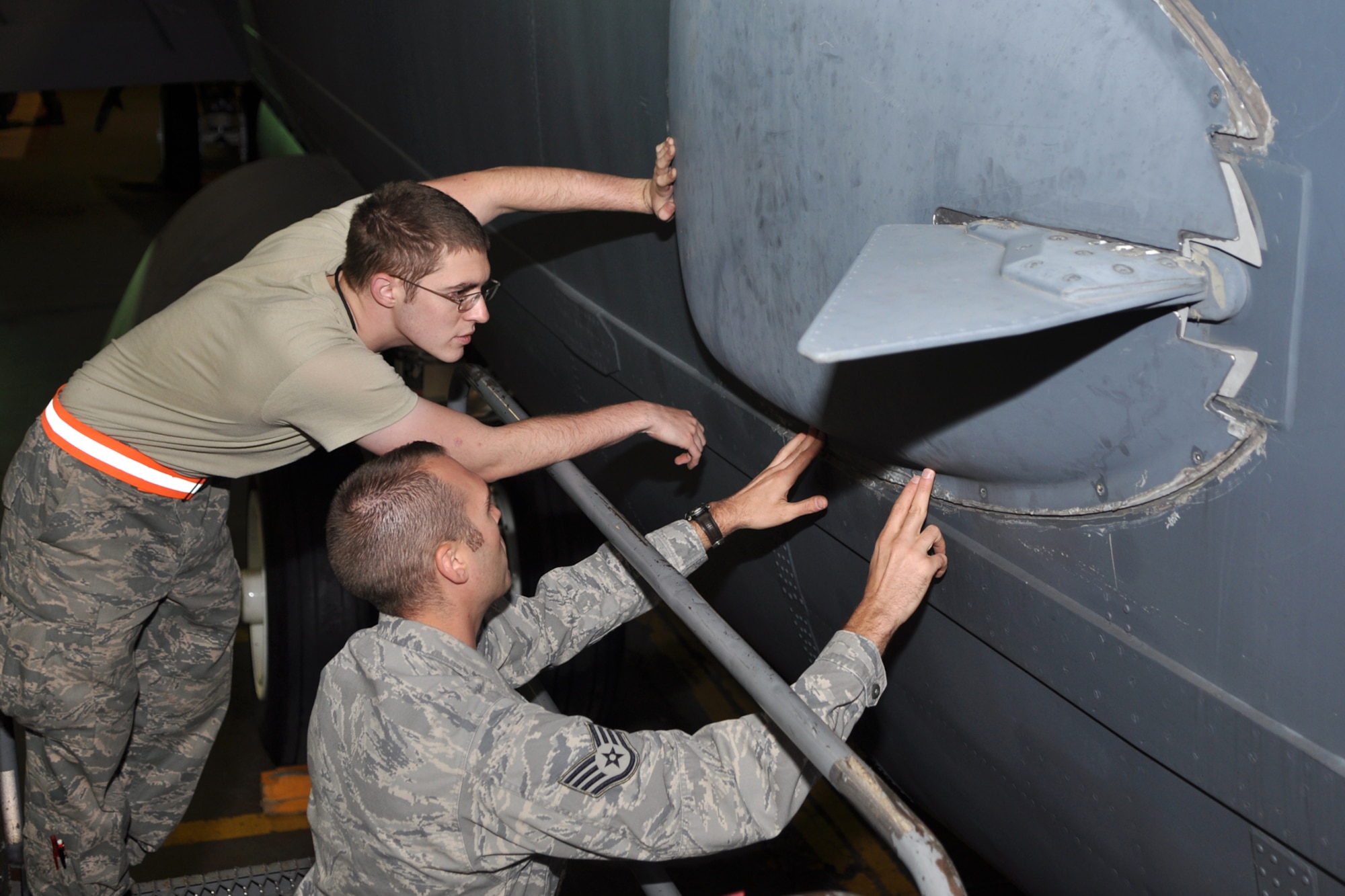 Staff Sgt. John Slaughter, 307th Maintenance Squadron, explains the procedure for reinstalling a miniature radio transmitter raydome to Airman 1st Class James Dameron, 5th Maintenance Squadron, at Minot Air Force Base, La., Sept. 5, 2012. Both Airmen are communications navigation systems technicians, and were replacing a seal during an antenna inspection. (U.S. Air Force photo by Master Sgt. Jeff Walston/Released)