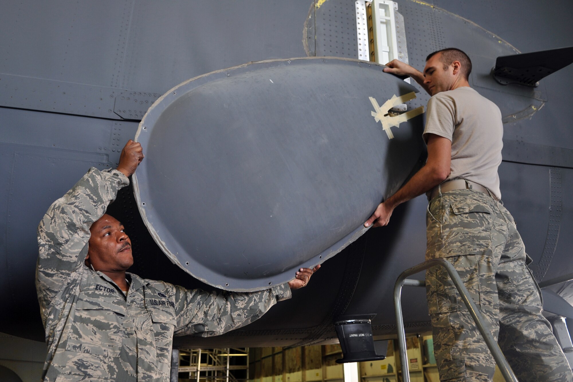 Staff Sgt. John Slaughter, 307th Maintenance Squadron, hands a miniature radio transmitter raydome to Tech. Sgt. Edward Ector, 5th Maintenance Squadron, at Minot Air Force Base, La., Sept. 4, 2012. Both Airmen are communications navigation systems technicians, and were replacing a seal during an antenna inspection. (U.S. Air Force photo by Master Sgt. Jeff Walston/Released)