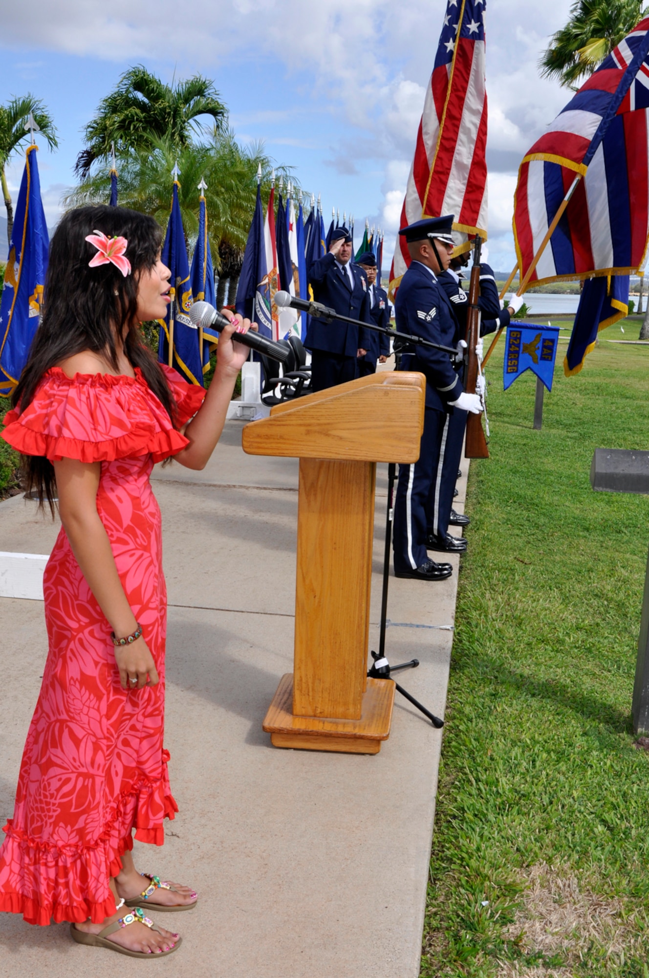 JOINT BASE PEARL HARBOR-HICKAM, Hawaii -- Cherry Mendoza sings the National Anthem while her father Col. Maynard “Max” Mendoza waits to assume command of the 624th Regional Support Group during a ceremony held Sept. 8 at the Missing Man Formation, Aloha Aina Park, here. Colonel Mendoza is now responsible for managing the largest Air Force Reserve presence in the Pacific, which is comprised of six units in Hawaii and Guam. The group provides combatant commanders more than 650 combat-ready Airmen who specialize in aerial port, aeromedical staging, civil engineering and security forces operations for worldwide deployment. (Air Force photo by Master Sgt. Daniel Nathaniel III)