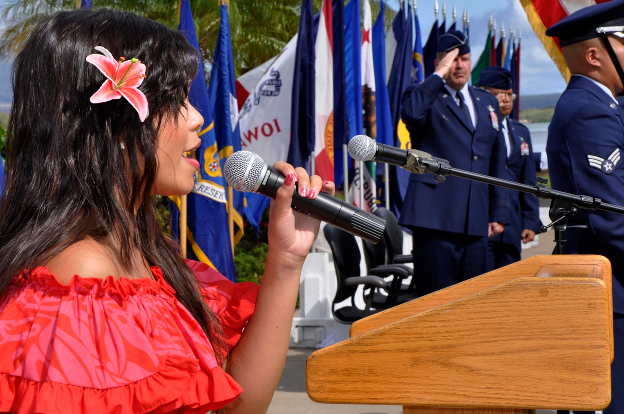 JOINT BASE PEARL HARBOR-HICKAM, Hawaii -- Cherry Mendoza sings the National Anthem while her father Col. Maynard “Max” Mendoza waits to assume command of the 624th Regional Support Group during a ceremony held Sept. 8 at the Missing Man Formation, Aloha Aina Park, here. Colonel Mendoza is now responsible for managing the largest Air Force Reserve presence in the Pacific, which is comprised of six units in Hawaii and Guam. The group provides combatant commanders more than 650 combat-ready Airmen who specialize in aerial port, aeromedical staging, civil engineering and security forces operations for worldwide deployment. (Air Force photo by Master Sgt. Daniel Nathaniel III)