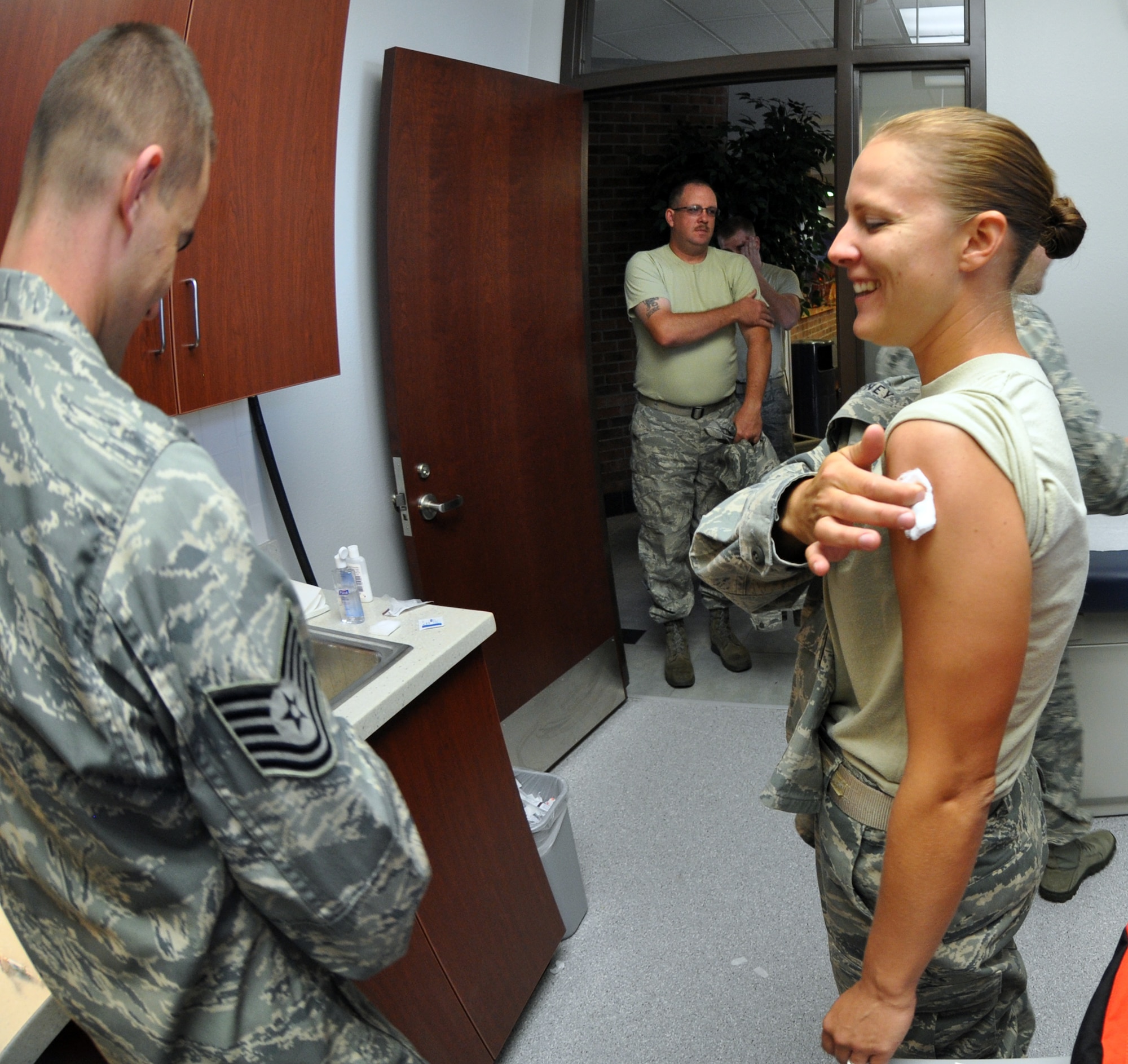 Tech. Sgt. Melany Money applies pressure to her arm moments after Tech. Sgt. Kristopher Mitchell, a medical technician with the 302nd Aeromedical Staging Squadron, inoculates her with an influenza vaccination, Sept. 9, 2012, at Peterson Air Force Base, Colo. Every year, Air Force Reserve members are required to receive the vaccine to help ensure mission readiness. Money is the 302nd Airlift Wing ground safety manager. (U.S Air Force photo/Staff Sgt. Derrick Gildner)