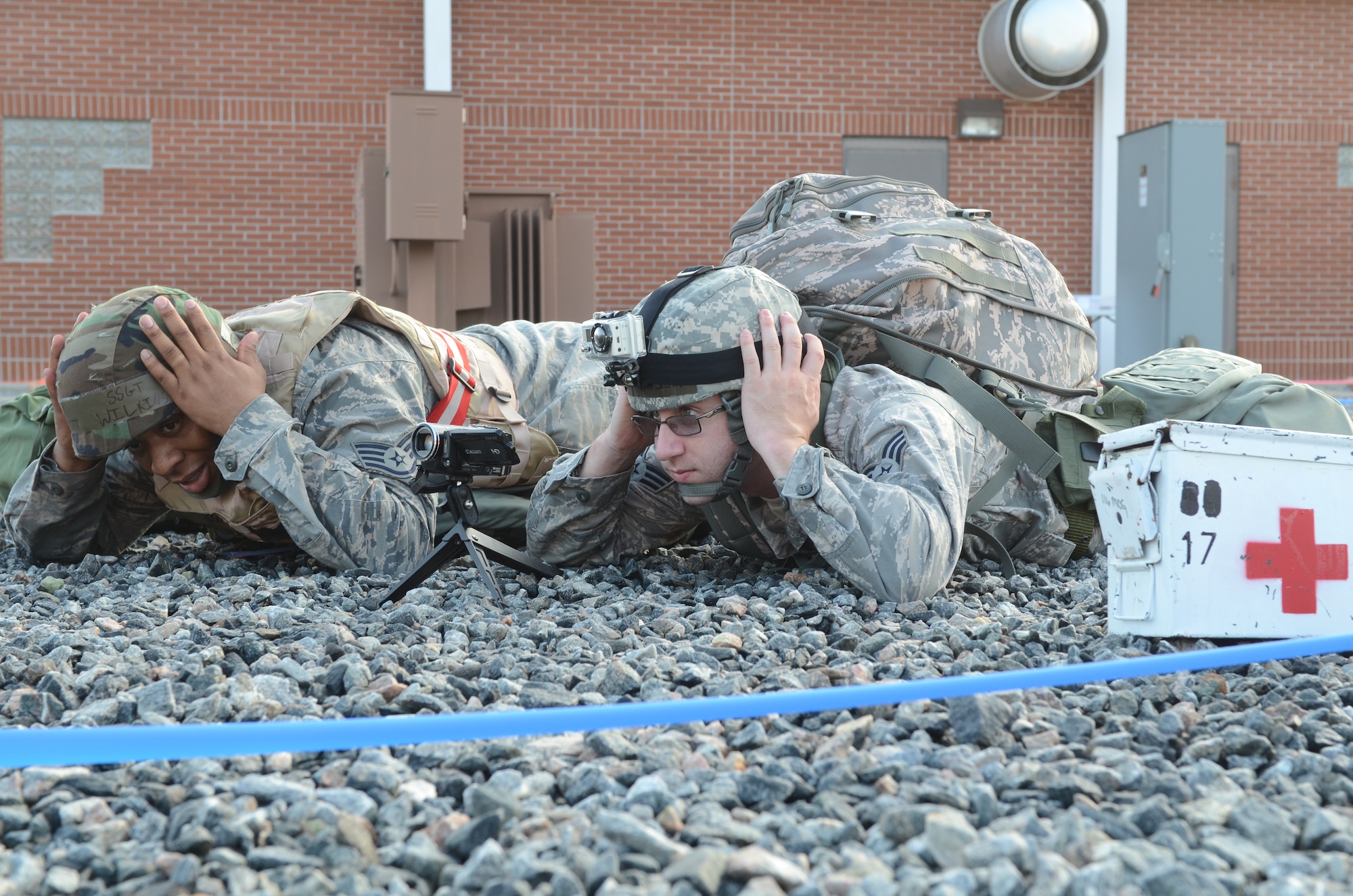 U.S. Air Force Tech. Sgt. Elliott Wilkins and Senior Airman Quinn Hansen with the 116th Air Control Wing, take cover after a simulated attack during an operational readiness inspection at Robins Air Force Base, Ga., Sept. 7, 2012.  Airmen from the 116th and 461st ACW are showcasing their ability to perform assigned tasks in wartime, contingency or force sustainment operation. Inspection areas include initial response, employment, mission support and ability-to-survive and operate in a chemical environment. (National Guard photo by Master Sgt. Roger Parsons/Released)