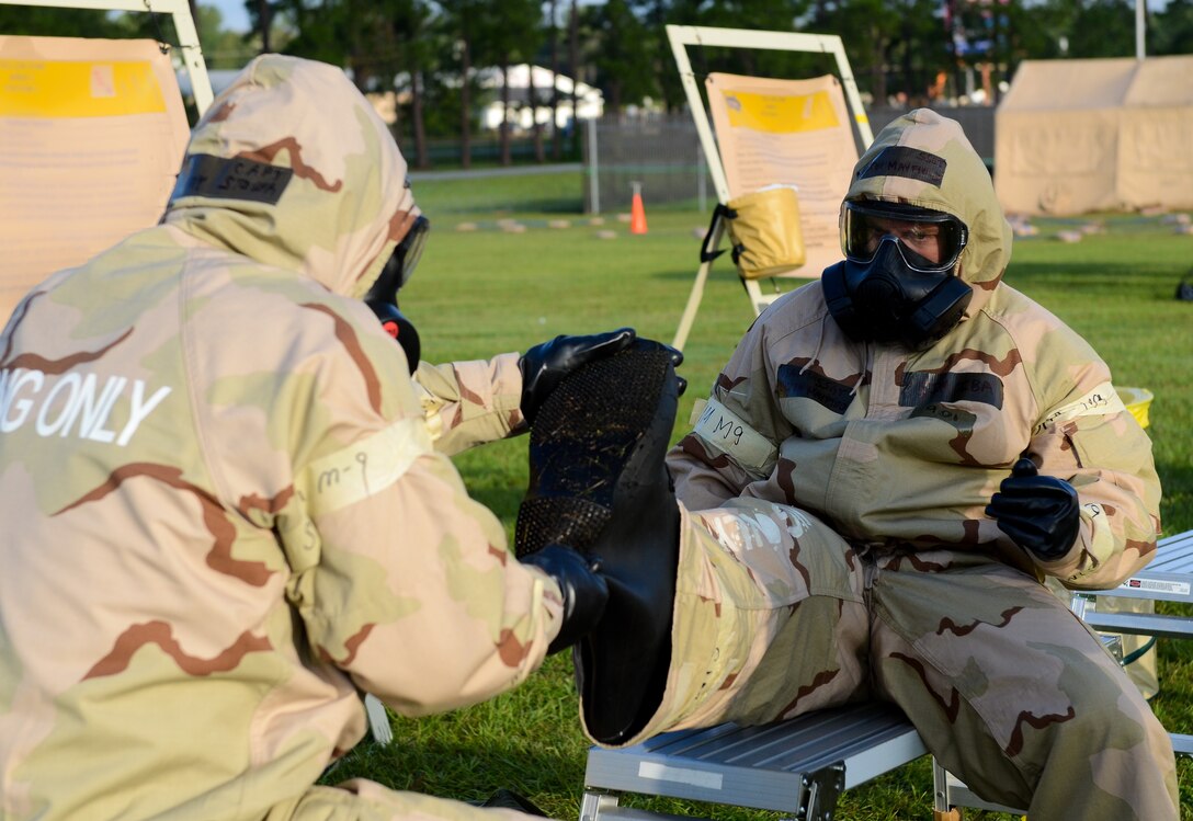 U.S. Air Force Airmen assist one another while processing through a contamination control area during an operational readiness inspection at Robins Air Force Base, Ga., Sept. 6, 2012. More than 500 Airmen simulated a deployment that tested basic knowledge such as self-aid and buddy care, and chemical, biological, radioactive nuclear and explosive responses. Portions of this image have been blurred for security reasons.
(National Guard photo by Master Sgt. Roger Parsons/Released)
