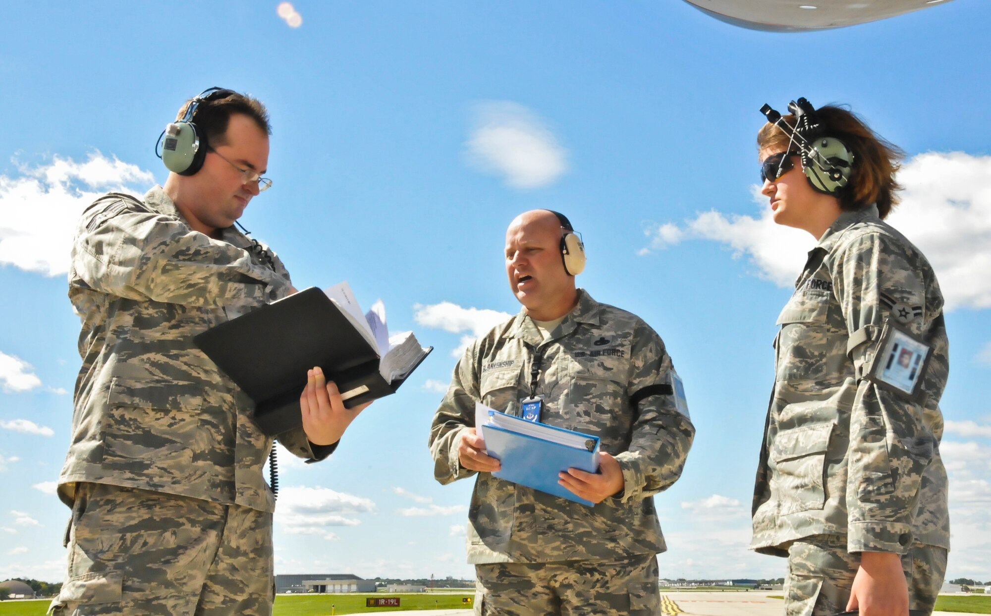 An Air Force Inspector, center, delivers instructions to members of the 128th Air Refueling Wing Maintenance Squadron, Staff Sgt. George Griffin and Airman 1st Class Elizabeth Kaiser, before evaluating their performance with an assigned task on a KC-135R Stratotanker located on the 128 ARW's ramp, in Milwaukee, Sept. 8,2012. The 128 ARW was undergoing a Compliance Inspection to gauge how accurately the base follows all assigned tasks, procedures, and protocols. (Air National Guard Photo by Staff Sgt. Jeremy M. Wilson / Released)