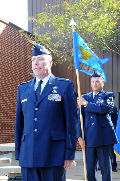 Sioux Falls, S.D. - South Dakota Air National Guard Chief Master Sgt. David Simons, 114th Communications Flight Plans and Resources Flight Chief, holds the guidon behind Major Kevin Miller, 114th Communications Flight commander, during a change of command ceremony Sept. 8, 2012. The ceremony introduced Major Miller as the 114th Communications Flight commander and congratulated Major Brent Post on his new position as the 114th Civil Engineer Squadron commander.(National Guard photo by Master Sgt. Christopher Stewart)(Released)