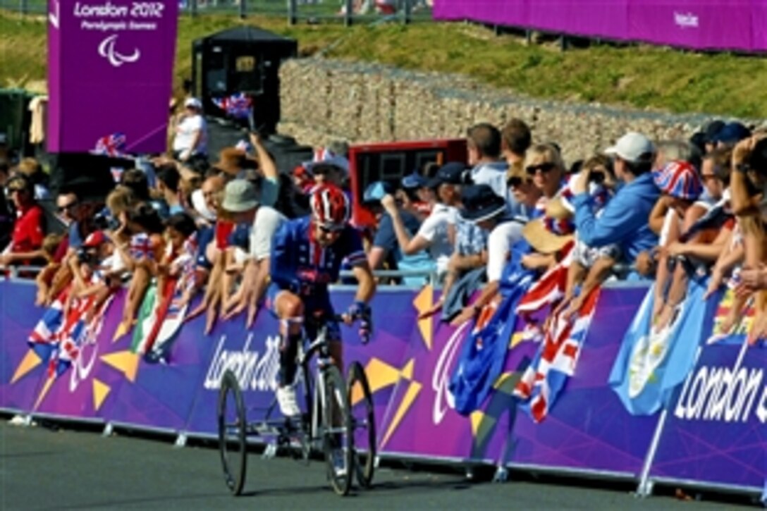 Steven Peace, a U.S. Navy veteran and U.S. Paralympic road cyclist, rides past fans while negotiating a hill as he completes the first of three laps for the 24-kilometer road race during the 2012 Paralympic Games in London, Sept. 8, 2012. 