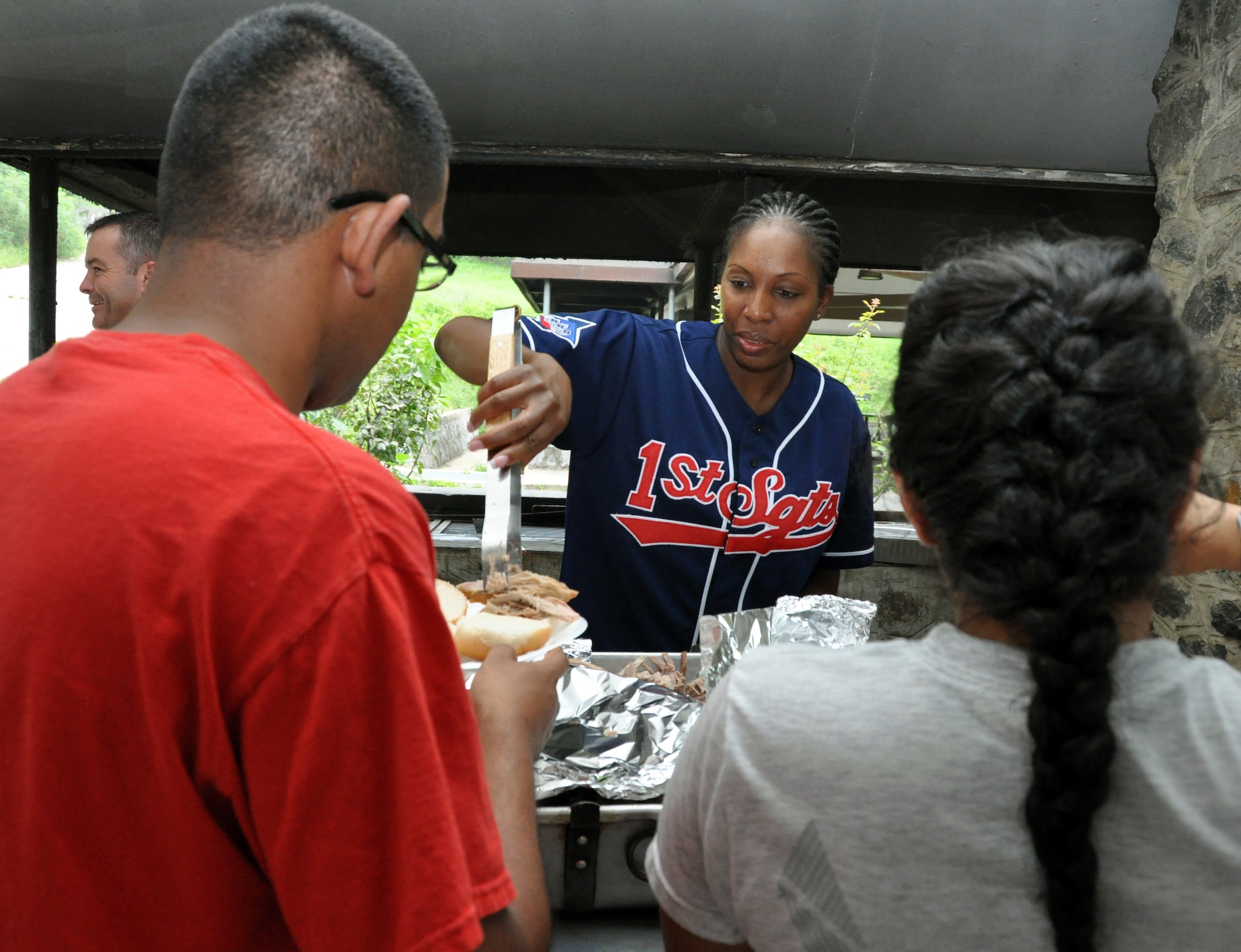 Master Sgt. Carol Dorman-Gore, 621st Air Control Squadron first sergeant, serves roasted pork sandwiches to Airmen during a first sergeant pig roast for single and unaccompanied Airmen at Osan Air Base, Republic of Korea, Sept. 7, 2012. The first-ever event was hosted and funded by the Osan First Sergeant Council. (U.S. Air Force photo/Senior Airman Michael Battles)