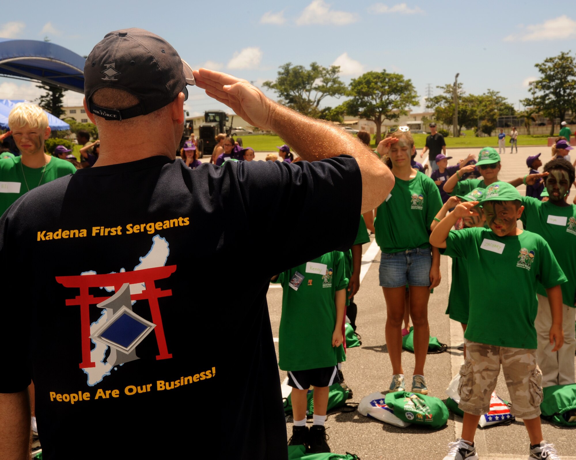 Senior Master Sgt. Robert Martin from the Kadena First Sergeants Association demonstrates drill movements to children participating in the Skoshi Warrior on Kadena Air Base, Sept. 8, 2012. Nearly 300 children from four services learned about how their parents deploy through a series of events and activities. (U.S. Air Force photo/Staff Sgt. Laszlo Babocsi)