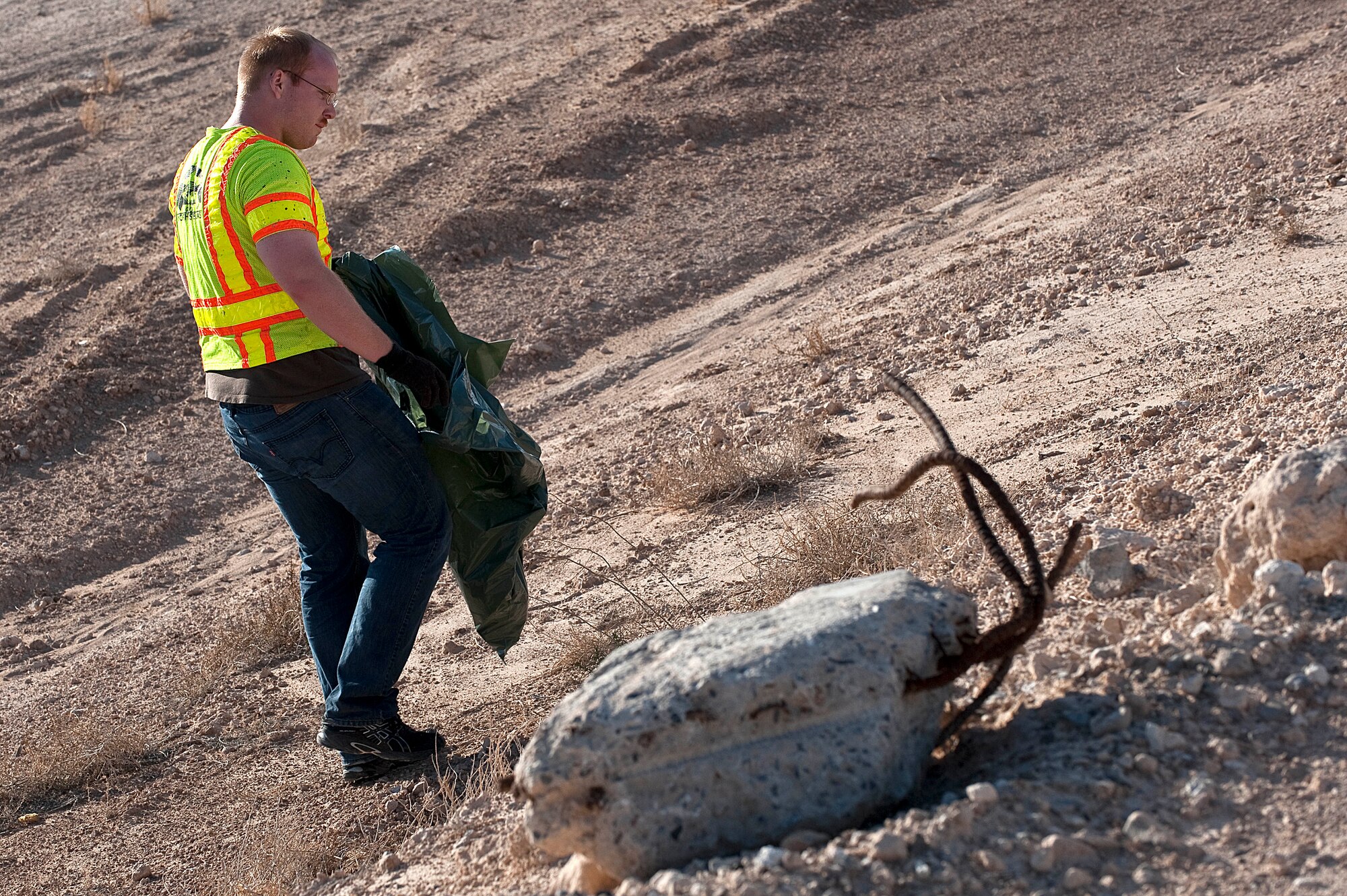 U.S. Air Force Airman 1st Class Spencer Strand, 99th Medical Support Squadron health services management technician, picks up trash near East El Campo Grande Avenue  Sept. 9 2012, in Las Vegas. Members of the 99th Medical Group coordinated Nellis Air Force Base participation with the city of North Las Vegas to pick up trash from East El Campo Grande Avenue, Sloan Lane and Linn Lane. 40 tons of trash was picked up. (U.S. Air Force photo by Staff Sgt. Christopher Hubenthal)