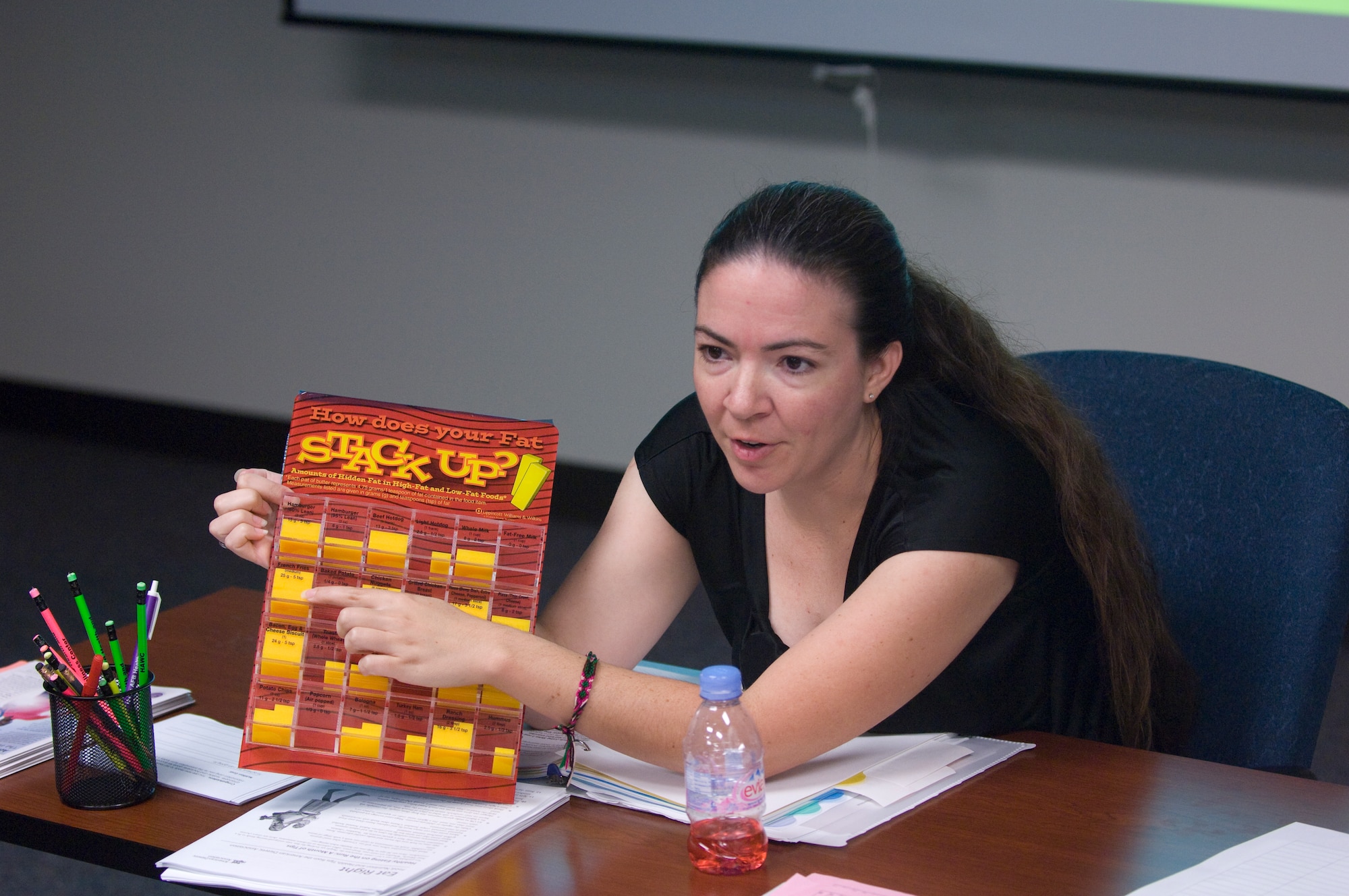 Lacy Puttuck, 99th Aerospace Medical Squadron Health and Wellness Center nutrition program manager, points out different popular food items on a fat content visual aid Sept. 7, 2012, at the HAWC to show students the fat content of their food choices. Puttuck teaches several classes at the HAWC to help Airmen, retirees, U.S. civilian employees and their family members start and maintain a healthier lifestyle. (U.S. Air Force photo by Senior Airman Jack Sanders)
