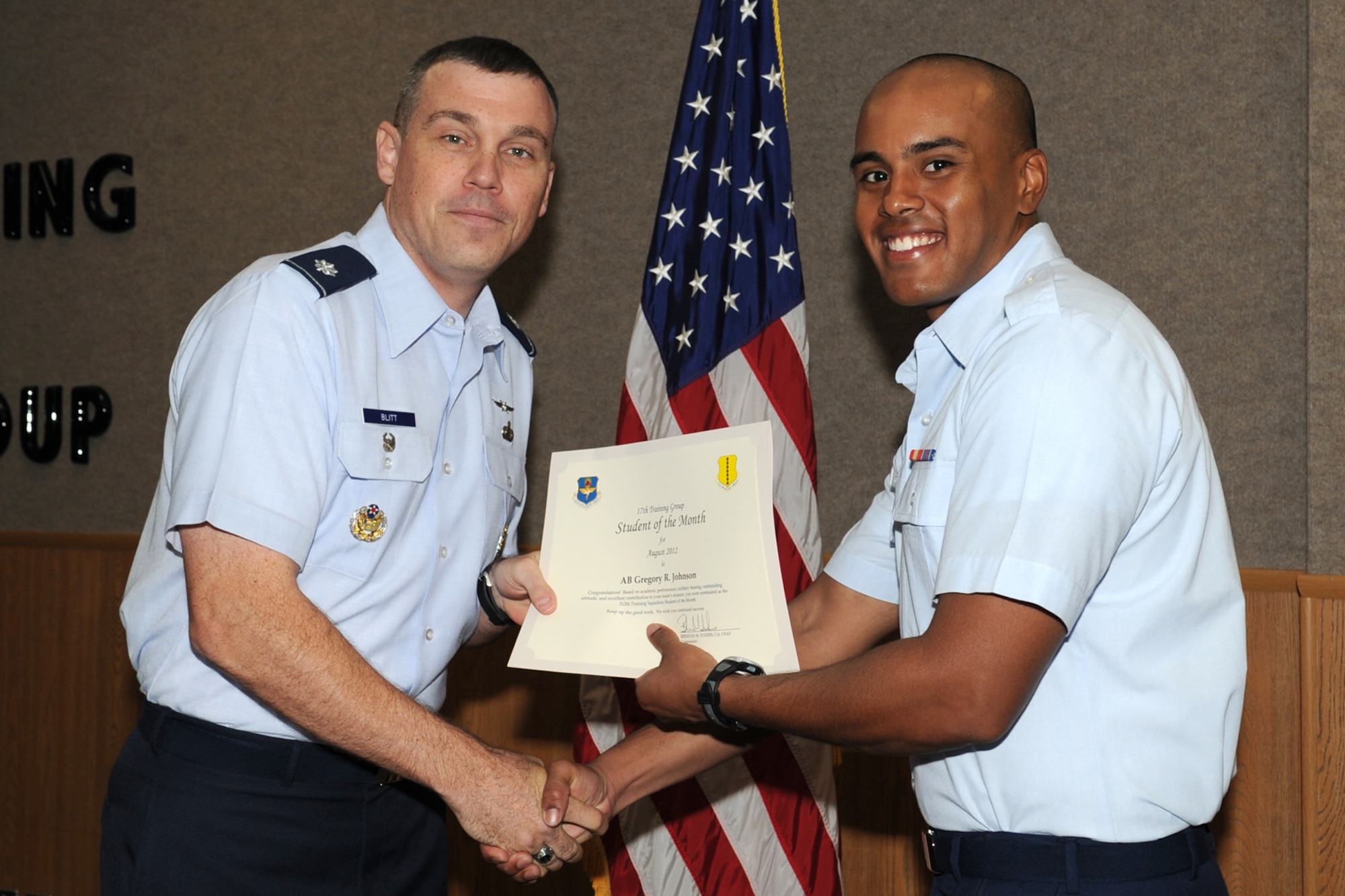 U.S. Air Force Lt. Col. Edward Blitt, 17th Training Group deputy commander, presents Airman Gregory Johnson with the 312th Training Squadron Student of the Month award for August at Goodfellow Air Force Base, Texas, Sept. 7, 2012. (U.S. Air Force photo by Staff Sgt. Laura R. McFarlane)