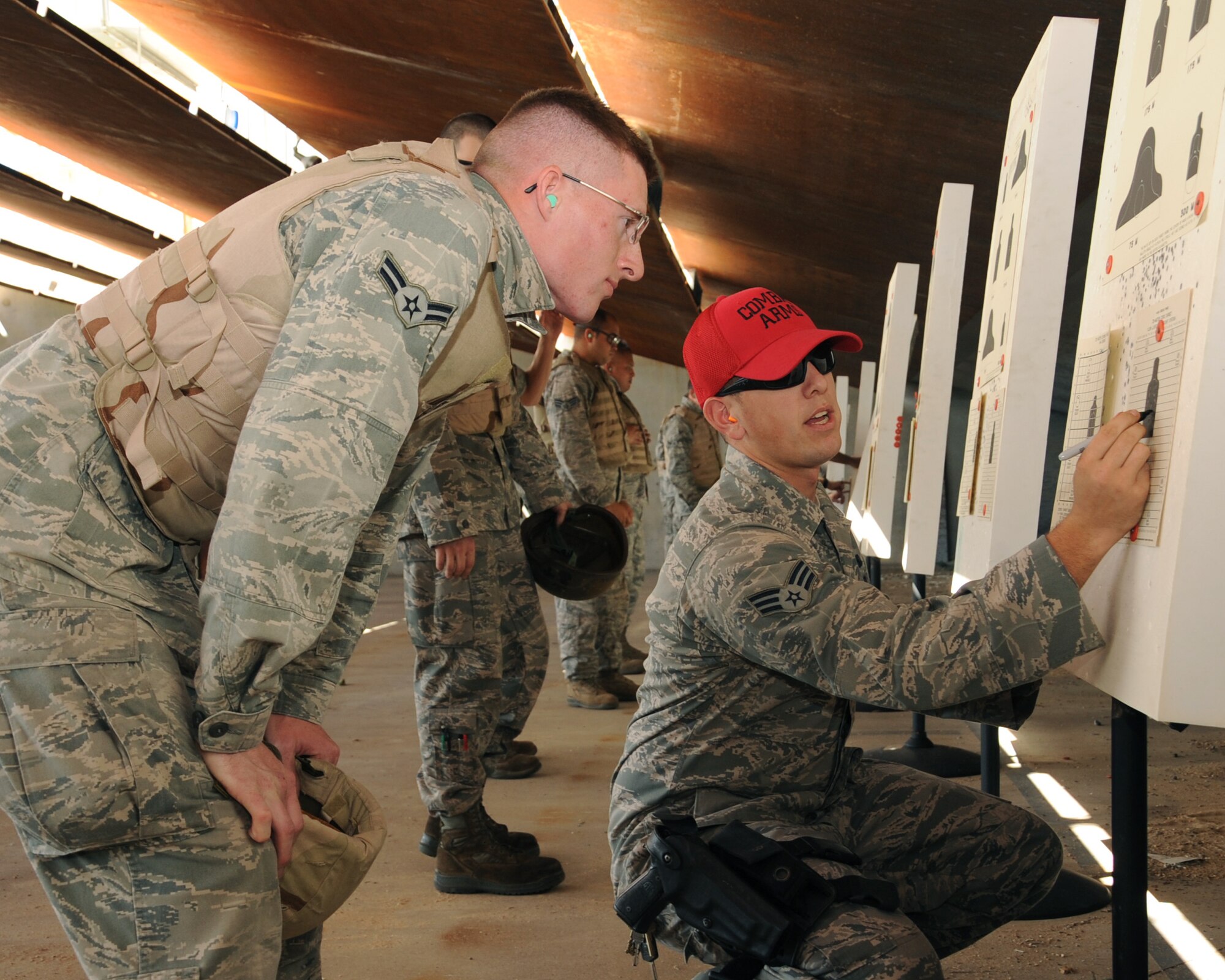 Senior Airman Drew Eaton, 2nd Security Forces Squadron combat arms instructor, evaluates a target shot by Airman 1st Class Collin Wanberg, 2nd Munitions Squadron munitions storage crew member, during M4 Carbine qualification on Barksdale Air Force Base, La., Sept. 10. The course is designed to ensure Barksdale Airmen have all the necessary training needed to protect themselves in a deployed environment. (U.S. Air Force photo/Senior Airman Sean Martin) (RELEASED)