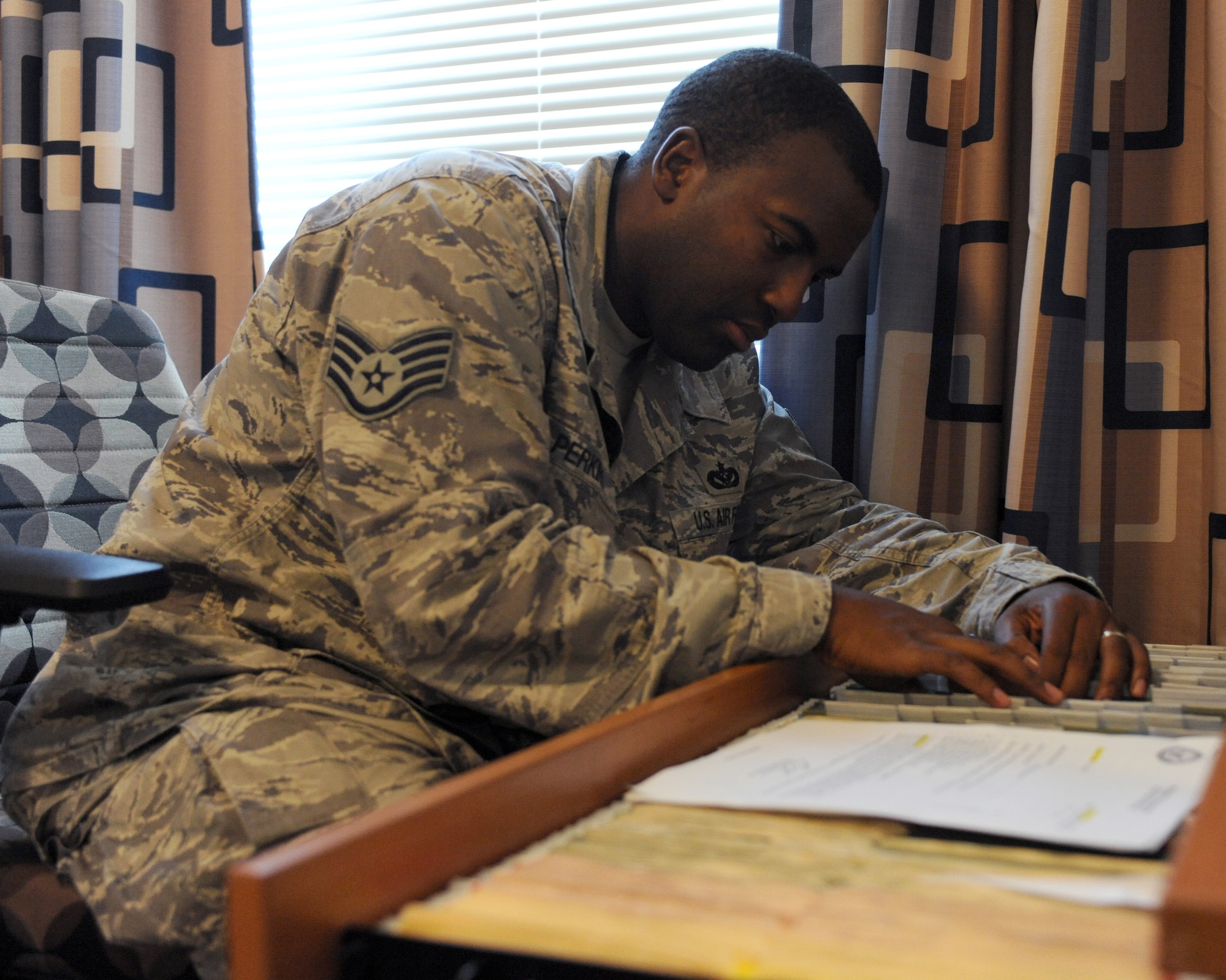 U.S. Air Force Staff Sgt. Earnest Perkins, 355th Civil Engineer Squadron Airman dormitory leader, files information on dorm residents on Davis-Monthan Air Force Base, Ariz., Sept. 5, 2012. The ADLs handle the needs and concerns of more than 600 Airmen in the dorms as well as the concerns of base leadership in regards to dorm residents. (U.S. Air Force photo by Airman 1st Class Timothy Moore/Released)