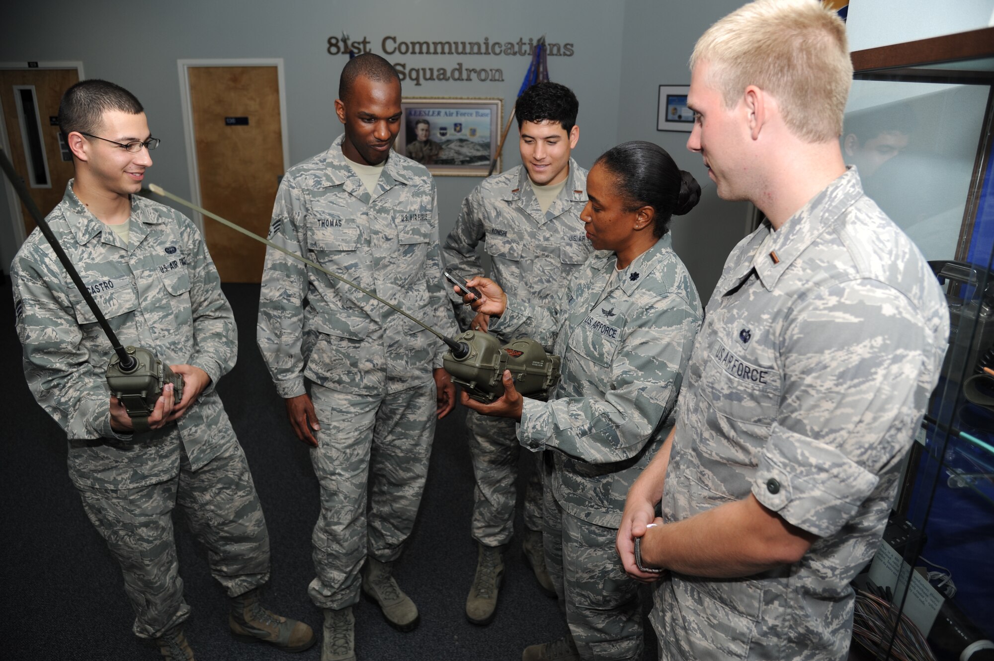 Senior Airmen Patrick Castro and Kenneth Thomas, and 2nd Lts. Nicholas Konishi and Joshua Huckabee, listen to Lt. Col. Rashone Tate, 81st Communications Squadron commander, as she discusses the advancements in information technology by showing them a cellular device used today compared to an antiquated field communications radio used many years ago Aug. 24, 2012, at the 81st CS building, Keesler Air Force Base, Miss.  (U.S. Air Force photos by Kemberly Groue)