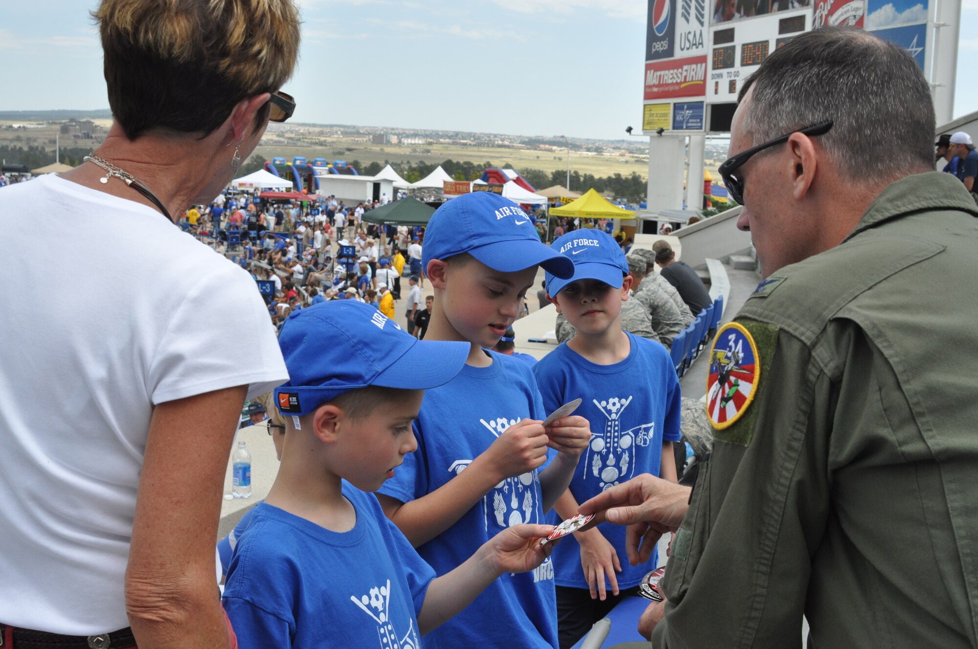 Col. Bill Lyons, 301st Fighter Wing Vice Commander, hands out Spad stickers to some future pilots during the second half of the Air Force Falcons vs. Idaho State Bengals NCAA Football Game, Saturday, September 1, 2012. He, with the Spads, performed the pregame flyover as part of their Cadet Sponsorship Program visit over the Labor Day Weekend. (U.S. Air Force Photo/SrA Jeremy Roman)