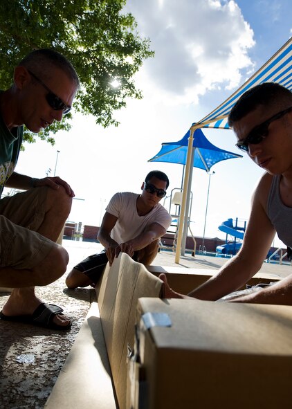 Members of the Dyess metal shop team build their boat Sept. 4, 2012, during a build-a-boat competition at Dyess Air Force Base, Texas. Participants were given one hour to build their boats from cardboard and duct tape, and row from one end of a pool to the other without sinking. This year’s winner was the Dyess metal shop team. (U.S. Air Force photo by Airman 1st Class Damon Kasberg/Released)
