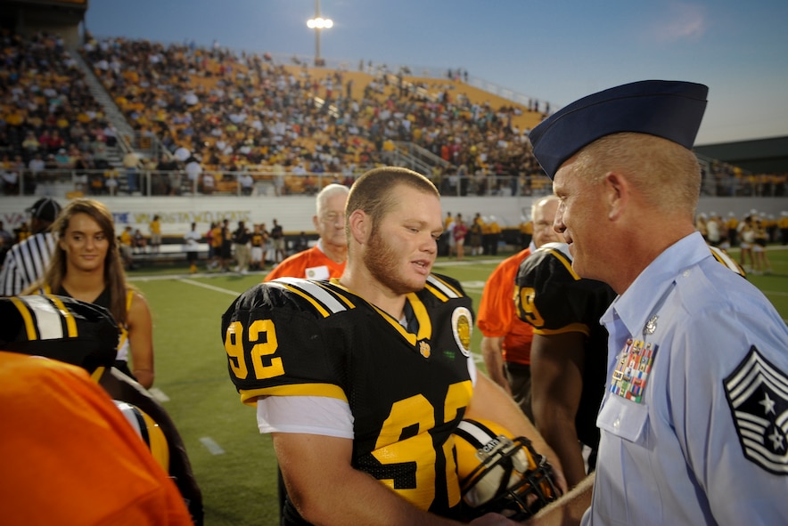 U.S. Air Force Chief Master Sgt. Frank Batten, 23d Wing command chief, shakes hands with members from the Valdosta High School Wildcats football team at the Bazemore-Hyder Stadium in Valdosta Ga., Sept. 7, 2012. Batten participated in the coin toss in recognition of Military Appreciation Day. (U.S. Air Force photo by Senior Airman Douglas Ellis/Released)

