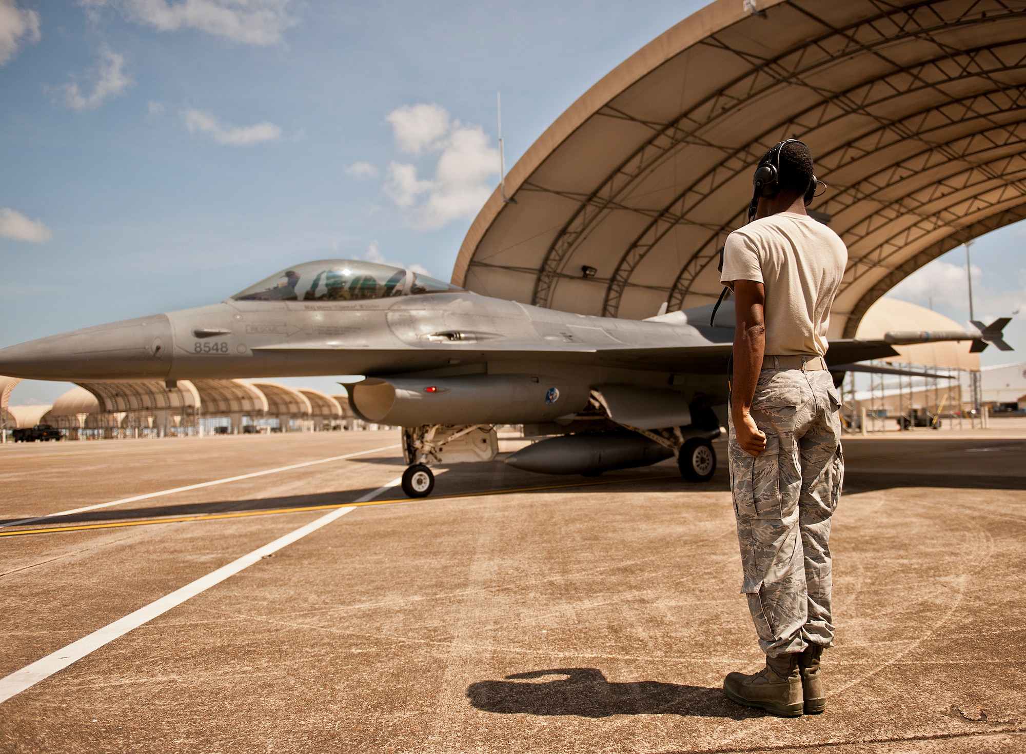 The pilot and crew chief salute each other as the F-16 Fighting Falcon taxies toward the runway for another sortie Sept. 6 at Eglin Air Force Base, Fla.  Approximately 36 Luke Air Force Base Airmen, assigned to the 309th, maintain four F-16s used as chase aircraft for F-35 flights and to maintain pilot proficiency.  Airmen from Luke’s various F-16 maintenance squadrons have been rotating to Eglin to support this mission since January 2011.  (U.S. Air Force photo/Samuel King Jr.)
