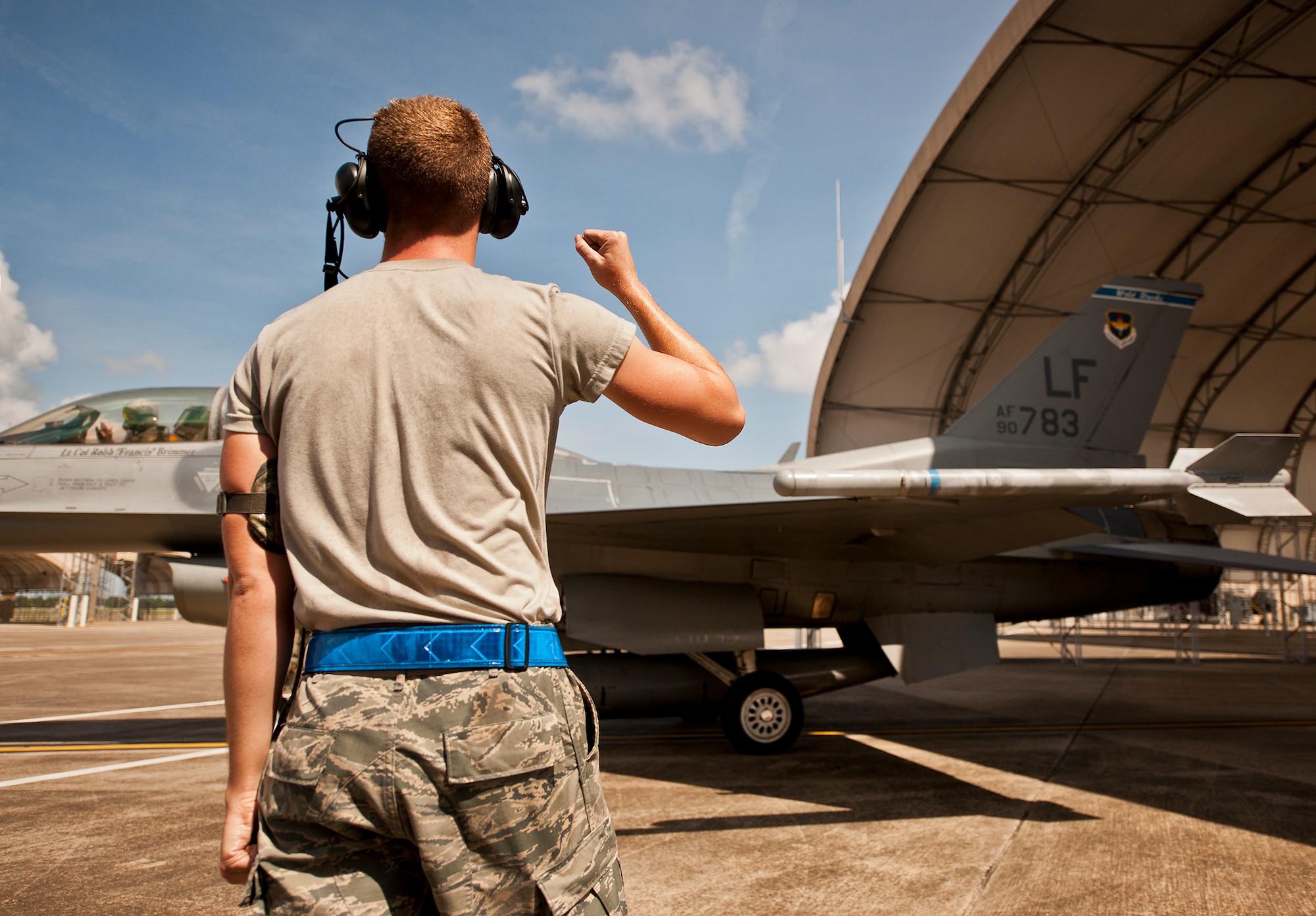 Senior Airman Branden Palmer, of the 309th Aircraft Maintenance Squadron, gives a celebratory fist pump after marshalling out an F-16 Fighting Falcon for another sortie Sept. 6 at Eglin Air Force Base, Fla.  Approximately 36 Luke Air Force Base Airmen, assigned to the 309th, maintain four F-16s used as chase aircraft for F-35 flights and to maintain pilot proficiency.  Airmen from Luke’s various F-16 maintenance squadrons have been rotating to Eglin to support this mission since January 2011.  (U.S. Air Force photo/Samuel King Jr.)