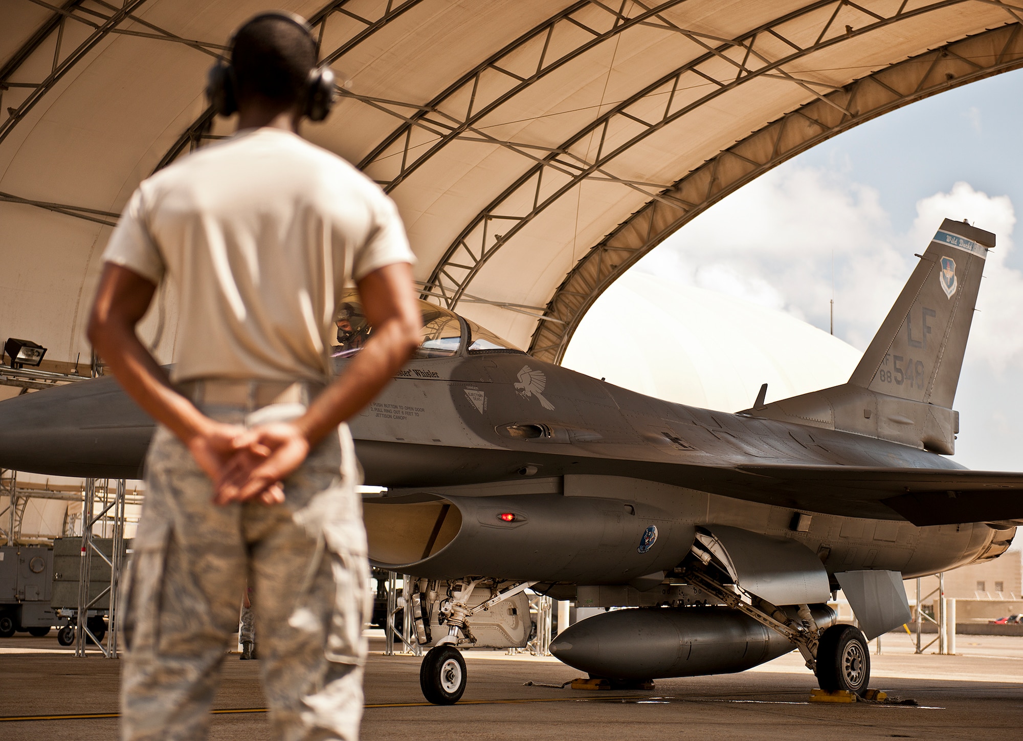 An F-16 crew chief waits to marshal out his F-16 Fighting Falcon for another sortie from the 33rd Fighter Wing flightline Sept. 6 at Eglin Air Force Base, Fla.  Approximately 36 Luke Air Force Base Airmen, assigned to the 309th, maintain four F-16s used as chase aircraft for F-35 flights and to maintain pilot proficiency.  Airmen from Luke’s various F-16 maintenance squadrons have been rotating to Eglin to support this mission since January 2011.  (U.S. Air Force photo/Samuel King Jr.)