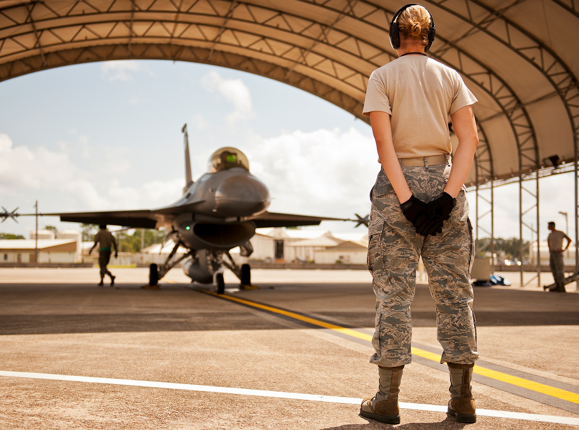 An Airman waits to give the weapons clearance to an F-16 Fighting Falcon prior to a sortie Sept. 6 at Eglin Air Force Base, Fla.  Approximately 36 Luke Air Force Base Airmen, assigned to the 309th, maintain four F-16s used as chase aircraft for F-35 flights and to maintain pilot proficiency.  Airmen from Luke’s various F-16 maintenance squadrons have been rotating to Eglin to support this mission since January 2011.  (U.S. Air Force photo/Samuel King Jr.)