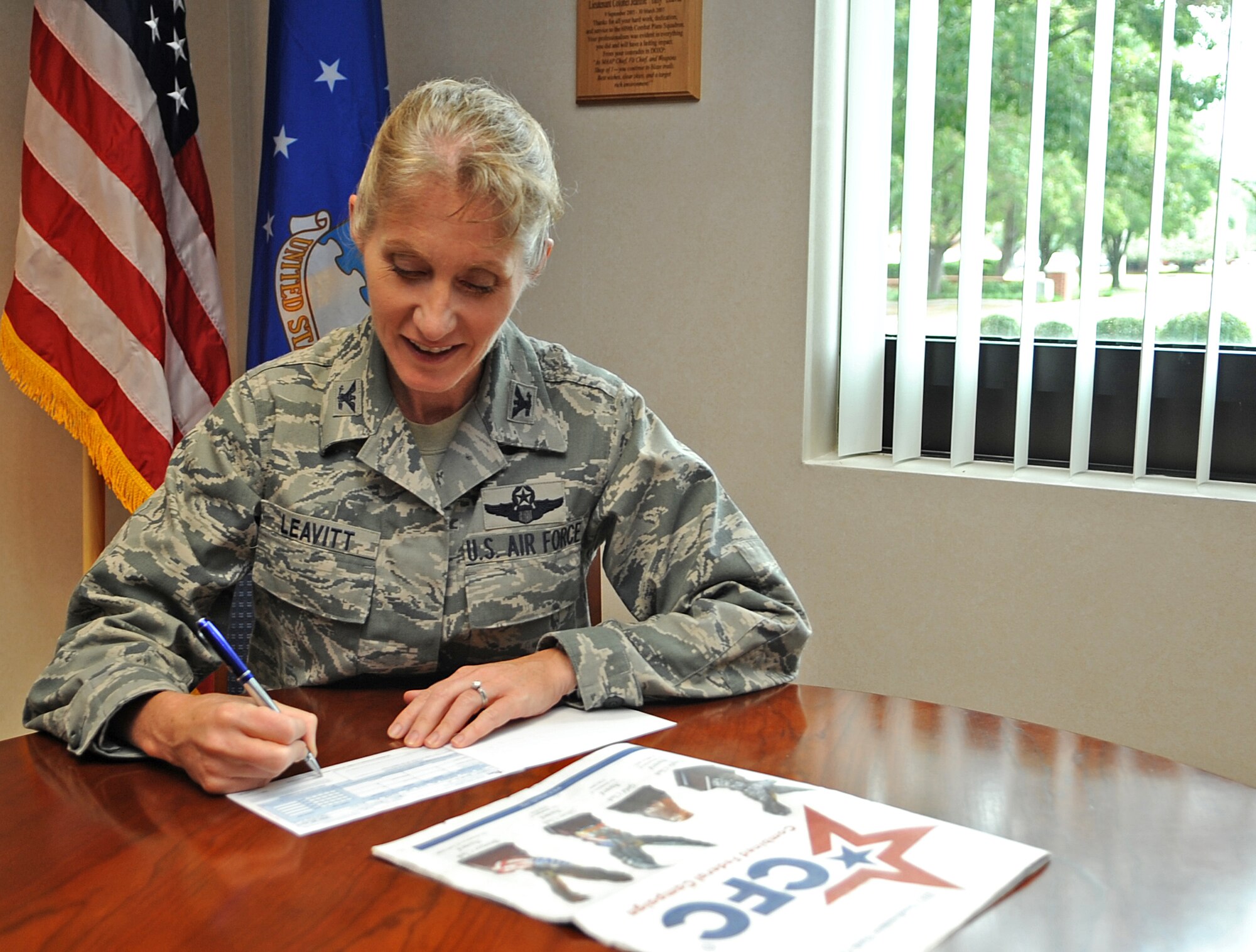 U.S. Air Force Col. Jeannie Leavitt, 4th Fighter Wing commander, signs her Combined Federal Campaign form to kick off the 4th Fighter Wing 2012 campaign here Sept. 7, 2012, N.C. Last year, Team Seymour exceeded its goal by $8,000, donating more than $225,000 to numerous local, national and international organizations. This year’s goal is $228,000. (U.S Air Force photo/Airman 1st Class Aubrey Robinson/Released)
