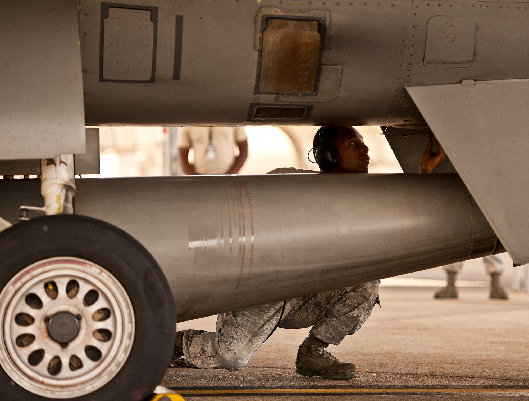 Senior Airman Dominique Wilson, a crew chief with the 309th Aircraft Maintenance Squadron, examines underneath an F-16 Fighting Falcon during pre-flight checks on the 33rd Fighter Wing flightline Sept. 6 at Eglin Air Force Base, Fla.  Approximately 36 Luke Air Force Base Airmen, assigned to the 309th, maintain four F-16s used as chase aircraft for F-35 flights and to maintain pilot proficiency.  Airmen from Luke’s various F-16 maintenance squadrons have been rotating to Eglin to support this mission since January 2011.  (U.S. Air Force photo/Samuel King Jr.)
