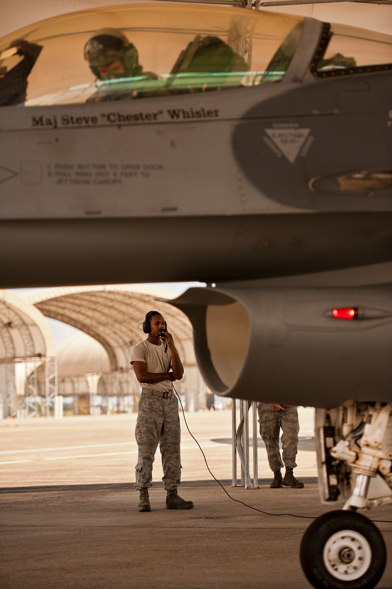 Senior Airman Dominique Wilson, a crew chief with the 309th Aircraft Maintenance Squadron, talks with the F-16 pilot over the radio during pre-flight checks on the 33rd Fighter Wing flightline Sept. 6 at Eglin Air Force Base, Fla.  Approximately 36 Luke Air Force Base Airmen, assigned to the 309th, maintain four F-16s used as chase aircraft for F-35 flights and to maintain pilot proficiency.  Airmen from Luke’s various F-16 maintenance squadrons have been rotating to Eglin to support this mission since January 2011.  (U.S. Air Force photo/Samuel King Jr.)