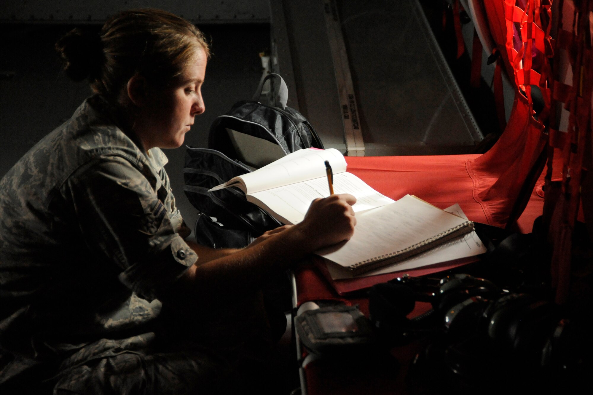 Airman 1st Class Brandie Nosakowski, a member of the 191st Aircraft Maintenance Squadron, utilizes light coming in a porthole window while on board a KC-135 Stratotanker flight to work on a skills upgrade training correspondence course, Sept. 7, 2012. Air Force personnel utilize a variety of formal classroom training, correspondence courses and on-the-job training to gain the skills necessary to become experts in their specific career field. Nosakowski is a member of the Michigan Air National Guard, based at Selfridge Air National Guard Base, Mich. (Air National Guard photo by John S. Swanson)