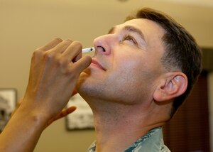 Col. Korvin Auch, 633rd Air Base Wing commander, inhales as he receives his flu immunization, Sept. 7, 2012, in the 633rd ABW headquarters building at Langley Air Force Base, Va. Immunizations are available for active-duty personnel and civilian employees Sept. 11 and 12, and Sept. 17 through 21 for all beneficiaries. (U.S. Air Force photo by Airman 1st Class R. Alex Durbin/Released)
