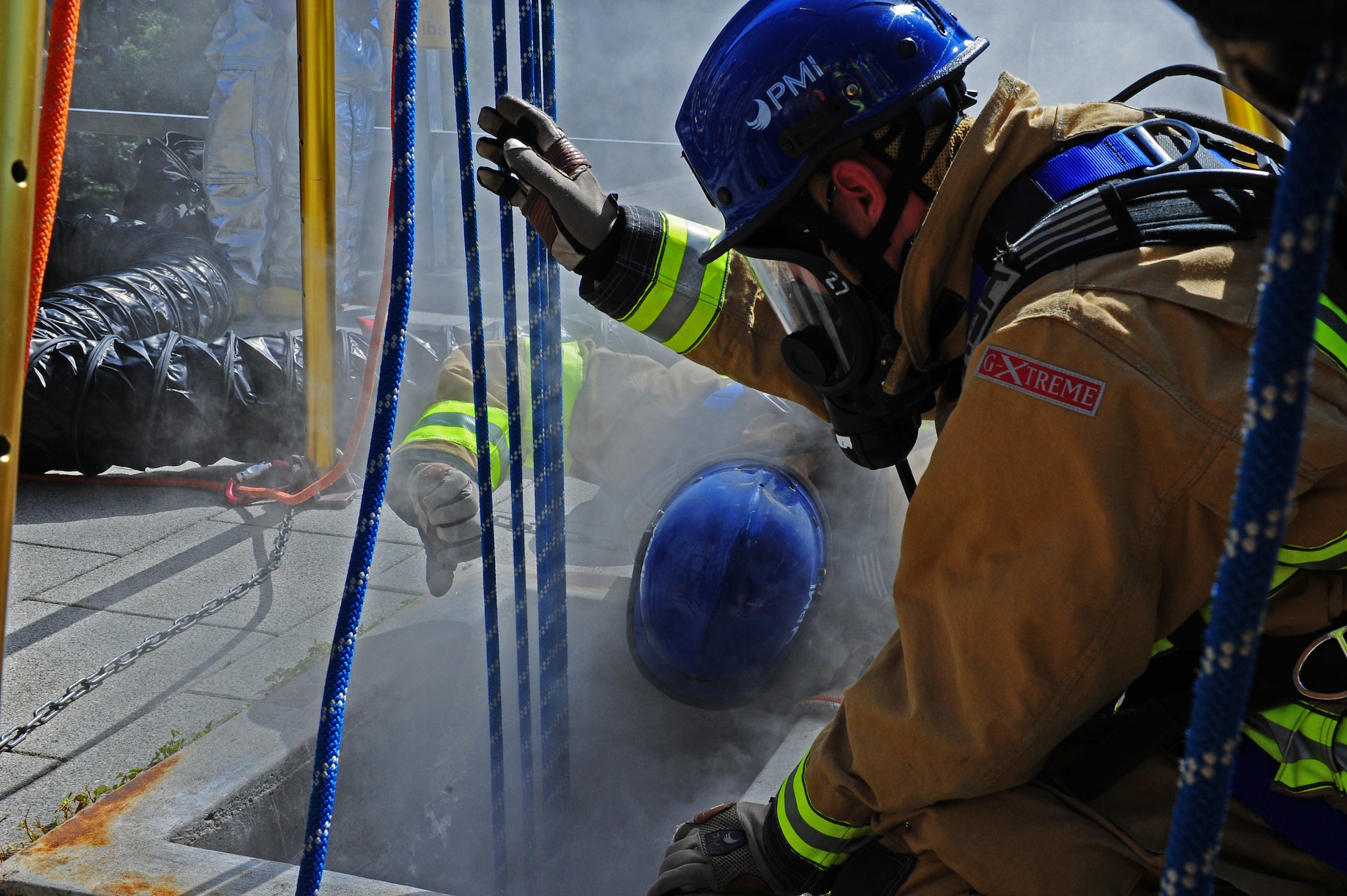 Airman 1st Class James Weaver, 886th Civil Engineer Squadron, and Staff Sgt. Aaron Scofield, 100th CES out of RAF Mildenhall, communicate with members of the rescue team during a constricted-space evaluation at the 435th Construction and Training Squadron compound on Ramstein Air Base, Germany, Sept. 6, 2011. The constricted-space evaluation was the final evaluatoin for students attending the U.S. Air Forces in Europe Fire Academy rescue technician course. (U.S. Air Force photo/A1C Holly Cook)