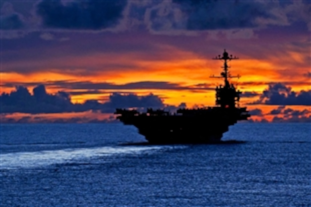 The aircraft carrier USS George Washington sails through calm seas near Guam at sunset while under way in the Pacific Ocean, Sept. 8, 2012. The George Washington is the centerpiece of Carrier Strike Group 5, the US Navy’s only continuously forward deployed carrier strike group, based out of Yokosuka, Japan. Carrier Strike Group 5 is currently on a routine Western Pacific patrol.