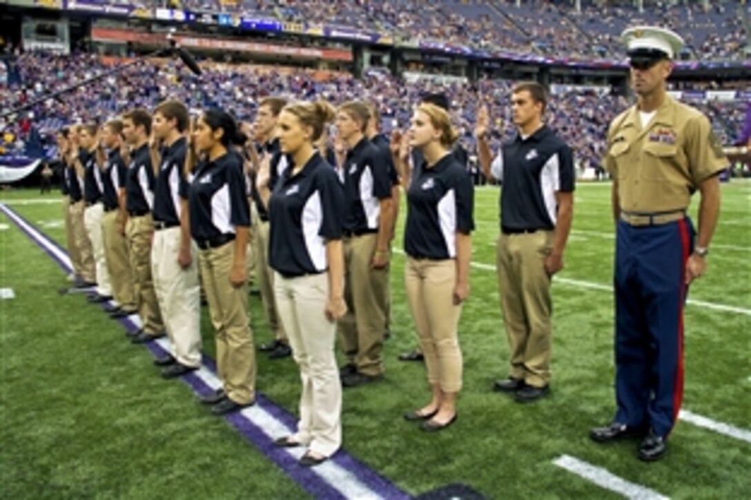Twenty-four aspiring Marines with Recruiting Station Twin Cities take the oath of enlistment before the Minnesota Vikings battle the Jackson Jaguars at the Metrodome in Minneapolis, Minn., Sept. 9, 2012.