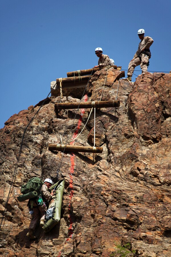Sgt. Jason Schmus, bottom left, and Master Sgt. Chris Brueggeman, center, mountain leaders with Battalion Landing Team 1st Battalion, 2nd Marine Regiment, 24th Marine Expeditionary Unit, conduct a tandem-lower as they move a casualty "dummy" down a 150 ft. cliff during a simulated mountain casualty evacuation in Djibouti, Aug. 29, 2012. The training is a part of a Training Force, or T-Force, package focused on primitive infantry skills. The 24th MEU is deployed with the Iwo Jima Amphibious Ready Group as a theater reserve and crisis response force throughout the U.S. Central Command in the Navy's 5th Fleet area of responsibility. Schmus is from Rosebush, Mich., and Brueggeman is from Cedar Creek, Mo.