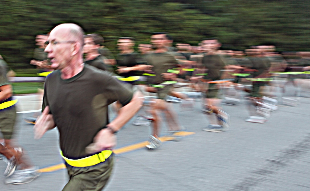 Marines with Headquarters Battalions race by during the battalion’s three mile run, Sept. 7.  The run afforded the large number of Marines in the battalion an opportunity to all participate in a group activity and interact with members that they may not normally be involved with.  