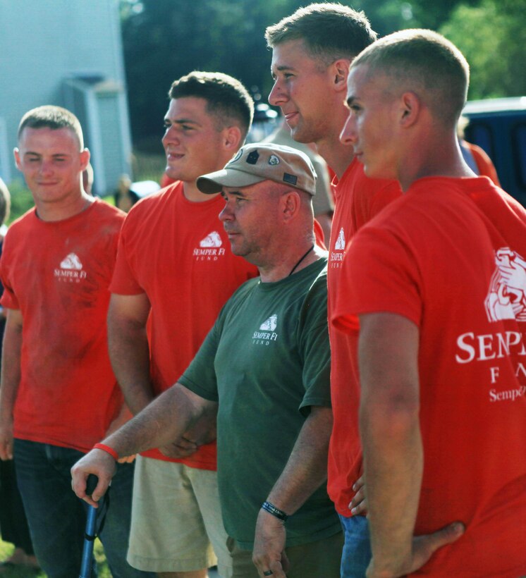 Sergeant Major Raymond Mackey (middle) stands amongst the Marine volunteers with the Semper Fi Fund, who helped renovate his house, Aug. 30.  Mackey, who lost both legs to an improvised explosive device in Afghanistan, 2009, had difficulty moving about his house on prosthetic legs.  The Semper Fi Fund and the Home Depot Foundation renovated his house to help alleviate some of the new obstacles he now encounters in a daily life.