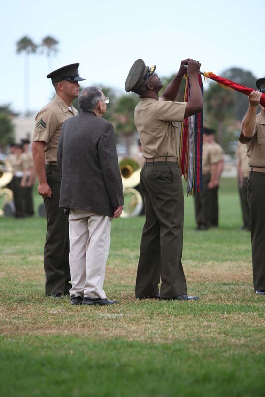 Major Gen. Ronald L. Bailey, the 1st Marine Division commanding general, fastens a streamer to the division battle colors during a battle color rededication ceremony on the division parade field here, Aug. 30. Bailey fastened 25 streamers to the battle color signifying various campaigns, expeditions, battles, and decorations presented to the division since its founding, from the occupation of Haiti in 1915 to Operation Enduring Freedom in Afghanistan. The ceremony was directed by the commanding general of the 1st Marine Division as a part of the Commandant’s guidance to refocus Marines on their core values and identity. (U.S. Marine Corps photo by Cpl. Sarah B. Novotny)