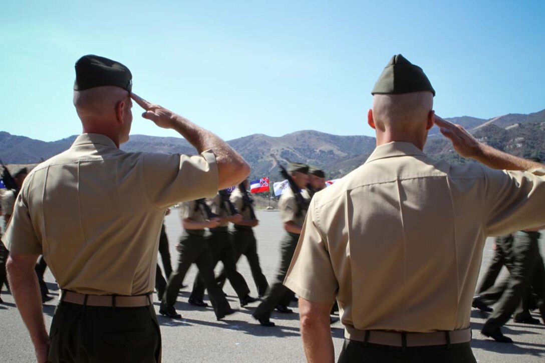 Lieutenant Colonel Kevin A. Norton (left) and Maj. Christopher J. Bronzi salute during the pass and review portion of a change of command ceremony where Norton relinquished command of 1st Battalion, 4th Marine Regiment, to Bronzi here Sept. 6, 2012.