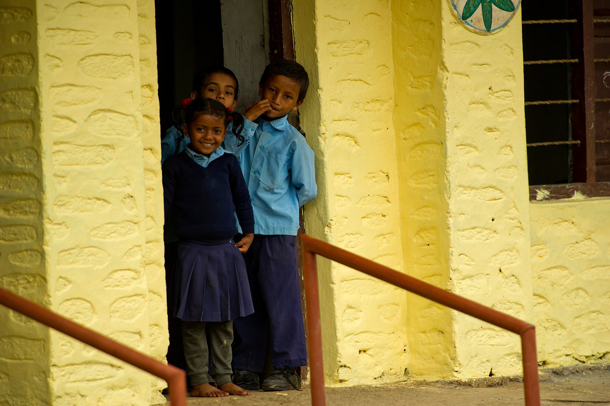 Nepali school children gather in a doorway to watch a team of U.S. Air Force and Nepalese Army civil engineers make repairs to their school during U.S. Pacific Command's Operation Pacific Angel 12-4, Nepal on Sept. 10, 2012. Pacific Angel 12-4 is a Pacific Air Forces planned event that enhances humanitarian assistance and disaster relief capabilities between the United States and Pacific partners. The U.S. was invited by the Nepal government to provide support by conducting medical, optometry, and civil engineering programs. Operations like Pacific Angel build and sustain relationships with our multinational partners in the Asia-Pacific region. (U.S. Air Force photo/Master Sgt. Jeffrey Allen)
