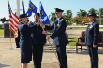 Lt. Col. Michael J. Fea takes the guidon from Col. Robie V. Hughes, Commander, 15th Medical Group, as he assumes command of the 15th Medical Operations Squadron (MDOS), Joint Base Pearl Harbor-Hickam, Hawaii on 2 Aug 2012.  Lt. Col. Rene J. Chadwell (right) is the former 15th MDOS commander.  Photo by David D. Underwood, Jr.