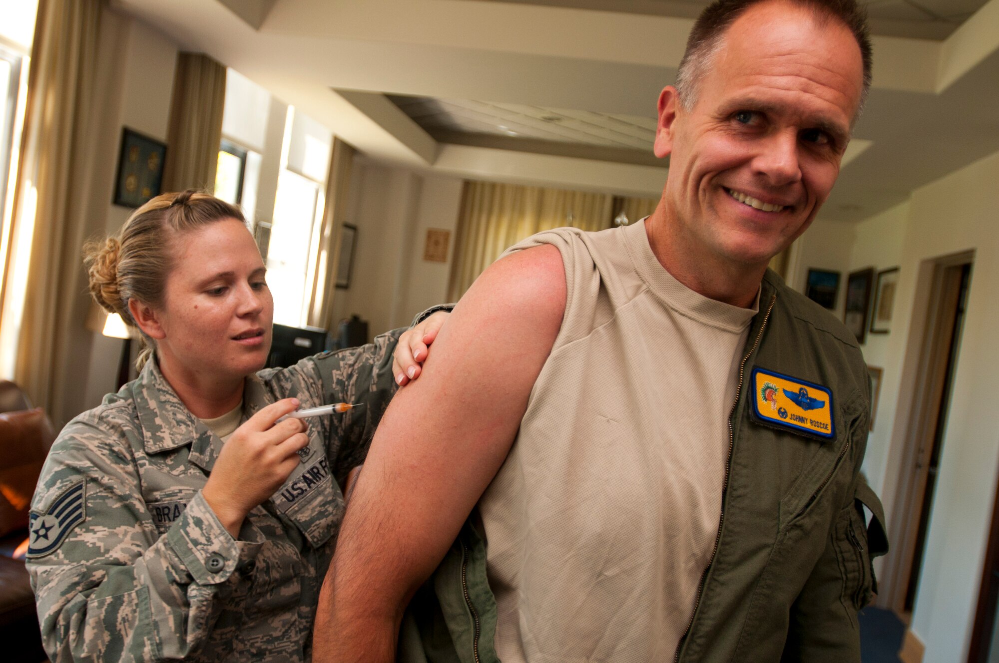 Staff Sgt. Aimee Braxton, 15th Medical Operations Squadron NCO in Charge of Immunizations, gives a shot to Col. Johnny Roscoe, 15th Wing commander, Sept. 6 at Joint Base Pearl Harbor-Hickam, Hawaii. These early immunizations were precursors to a larger mass-immunization exercise, or SHOTEX, to be conducted Sept. 18-20. (U.S. Air Force photo by Staff Sgt. Mike Meares)
