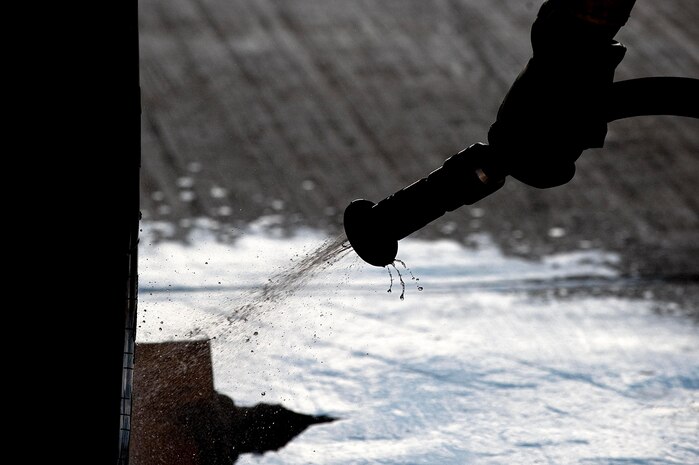 U.S. Air Force Airman 1st Class Garrett Sterba, 757th Aircraft Maintenance Squadron electronic environmental journeyman, hoses down a tire of an F-15E Strike Eagle at the wash rack here Sept. 10, 2012, at Nellis Air Force Base, Nev. Washing aircraft every 180 days at Nellis AFB helps to extend its life and reliability by preventing corrosion build-up. The more exposure an installation has to salt water the more frequently the aircraft is required to be washed.  (U.S. Air Force photo by Staff Sgt. Christopher Hubenthal)