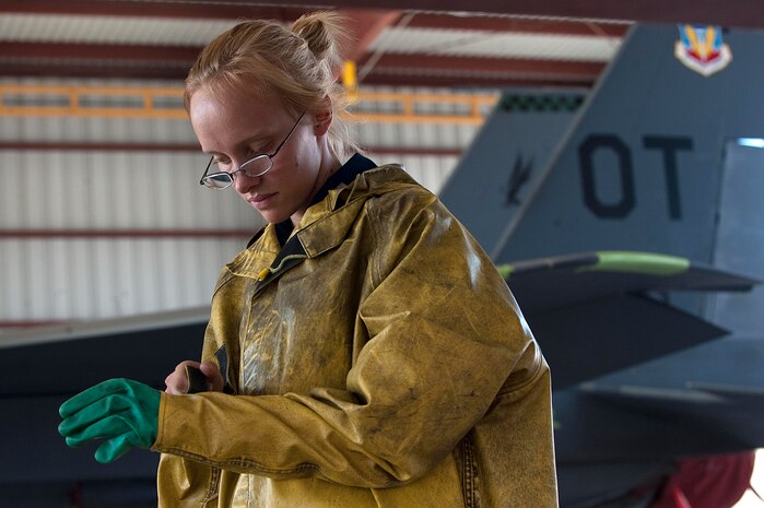 U.S. Air Force Senior Airman Candace Obeginski, 757th Aircraft Maintenance Squadron crew chief, puts on personal protective equipment prior to cleaning an F-15E Strike Eagle at the wash rack here Sept. 10, 2012, at Nellis Air Force Base, Nev. Washing aircraft every 180 days at Nellis AFB helps to extend its life and reliability by preventing corrosion build-up. The more exposure an installation has to salt water the more frequently the aircraft is required to be washed. (U.S. Air Force photo by Staff Sgt. Christopher Hubenthal)